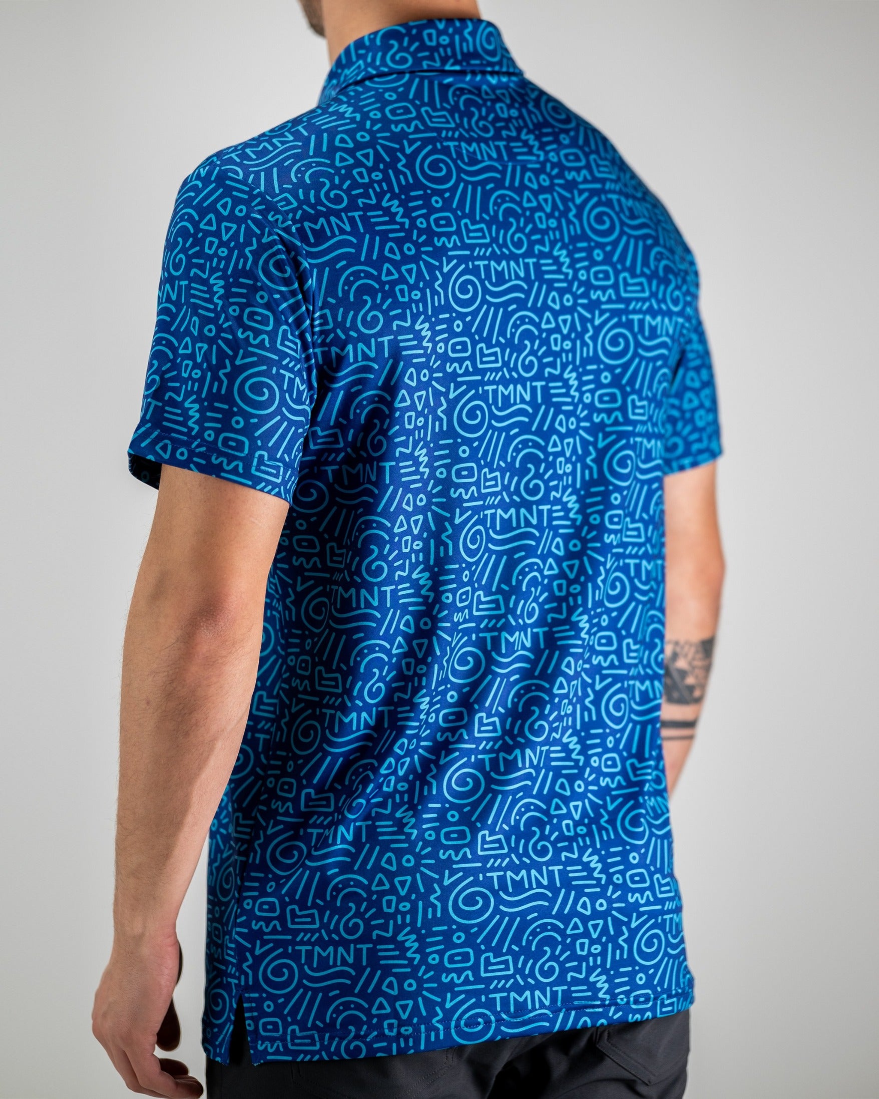 Men's blue polo shirt featuring a playful TMNT doodle pattern, perfect for fans looking to showcase their style on the golf course.