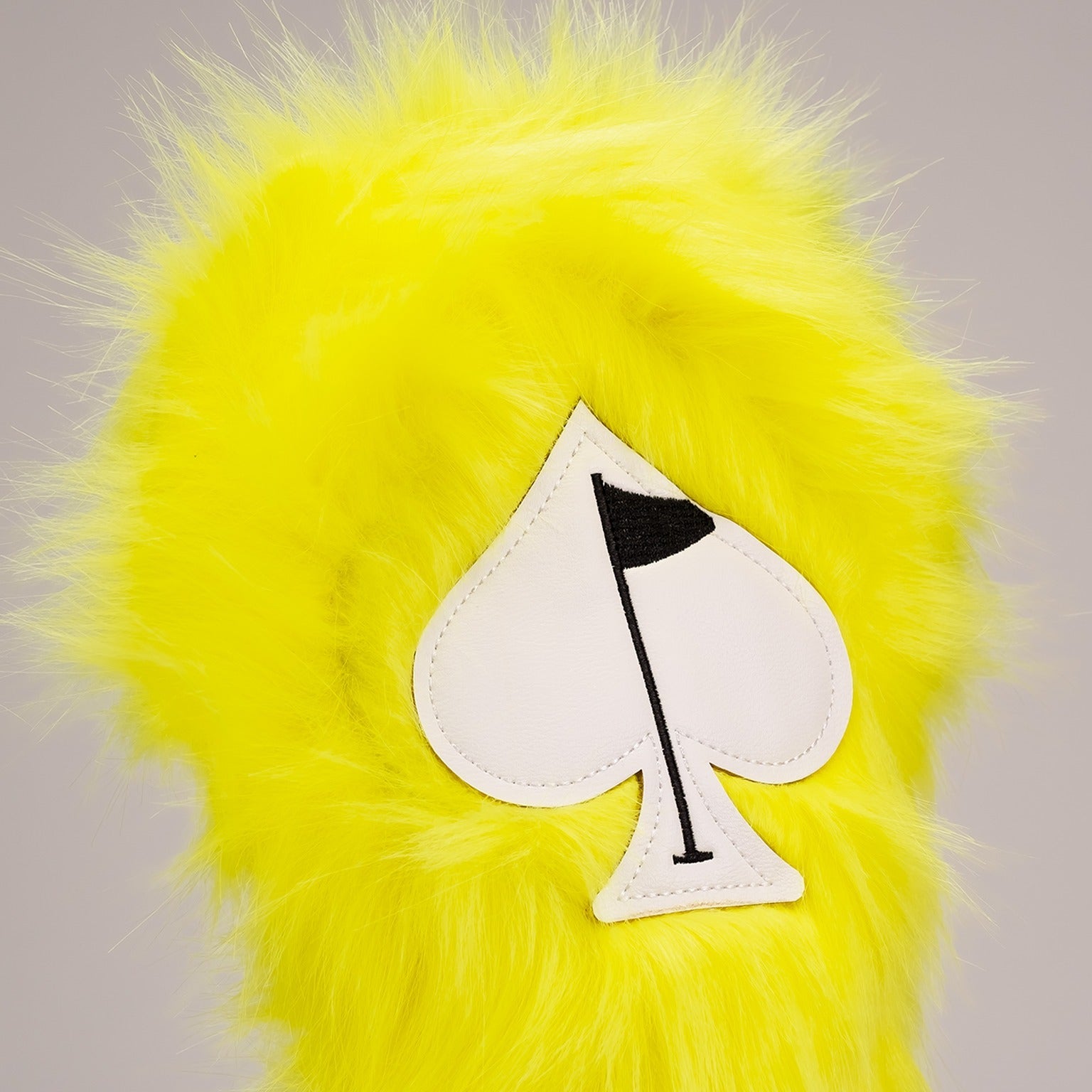 Bright yellow fuzzy fairway cover featuring a spade logo, designed for golfers seeking a fun and unique accessory.