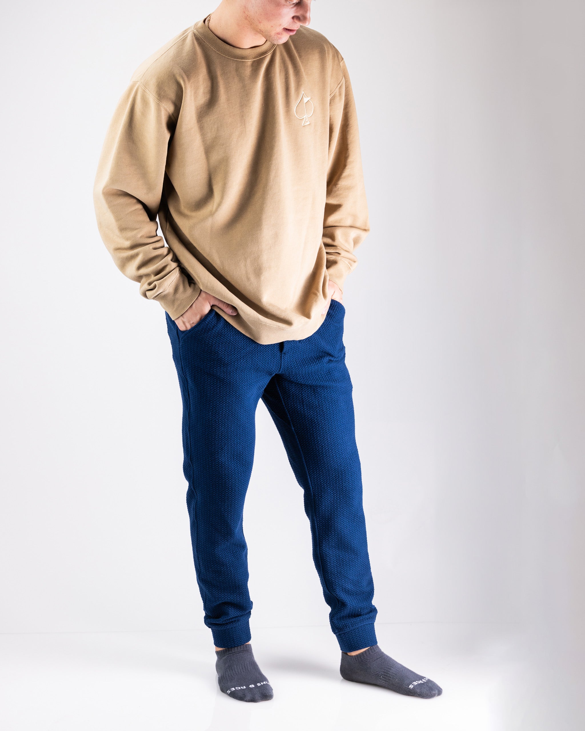 Comfortable men's waffle knit joggers in navy, paired with a beige long-sleeve shirt, perfect for casual wear.