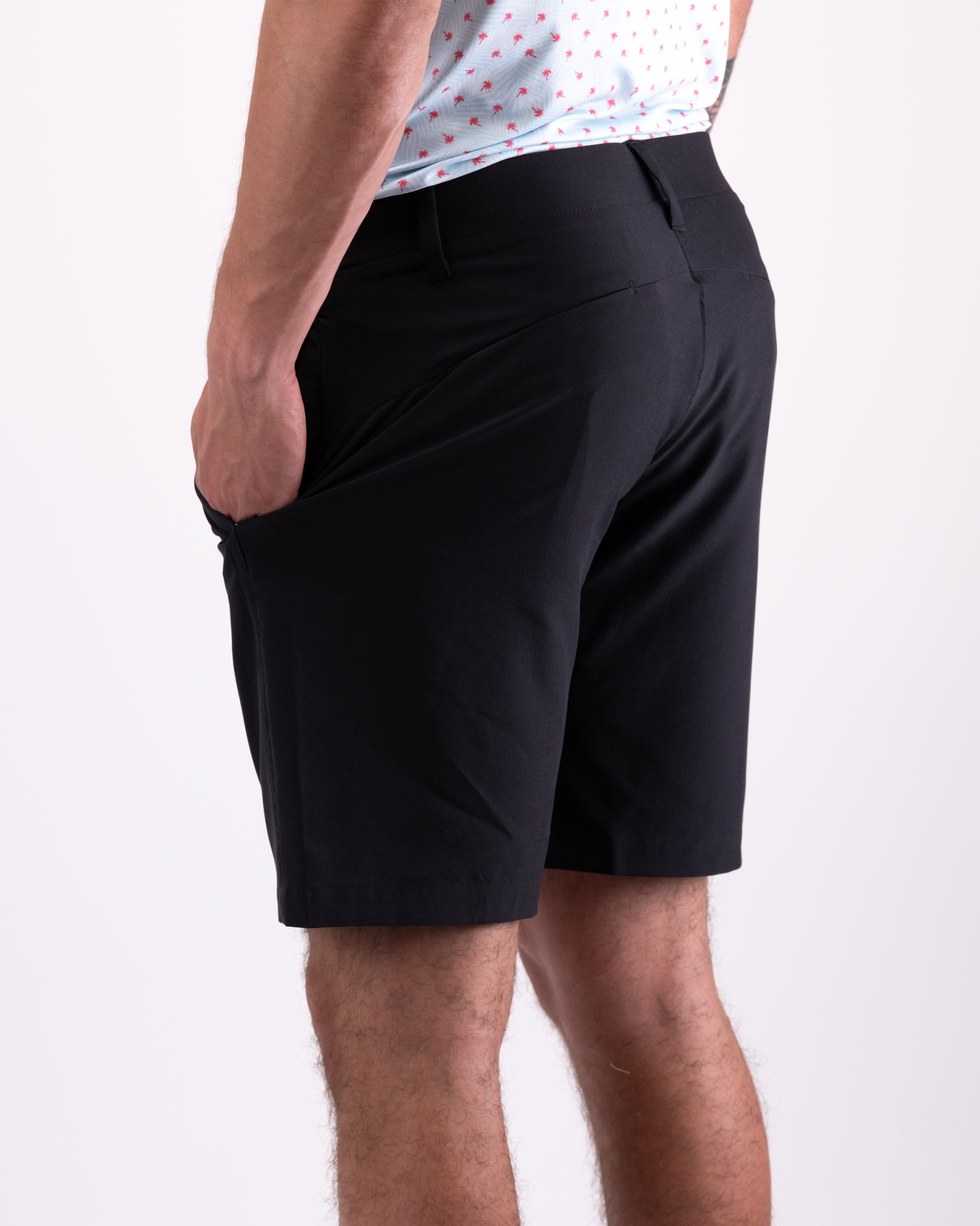 Men's black performance shorts featuring a sleek design and side pockets, ideal for comfort on the golf course.