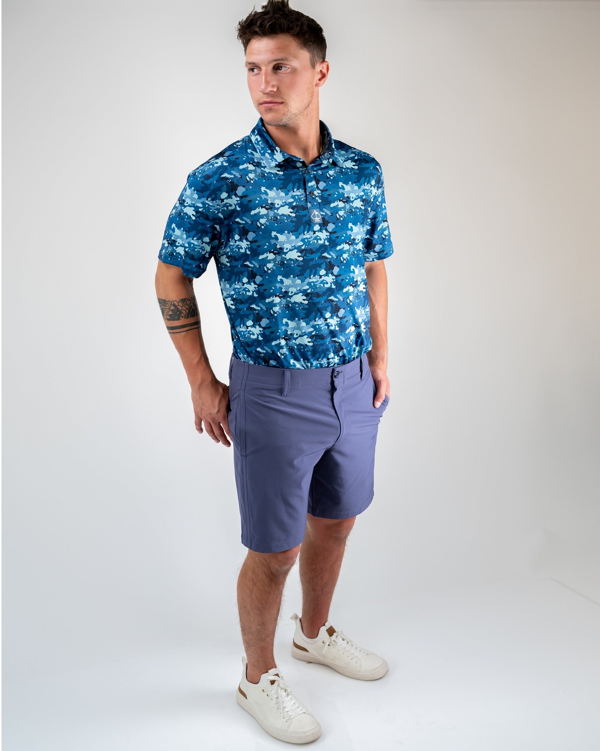Men's performance shorts in dusk color, paired with a blue floral polo shirt, ideal for stylish golf outings.