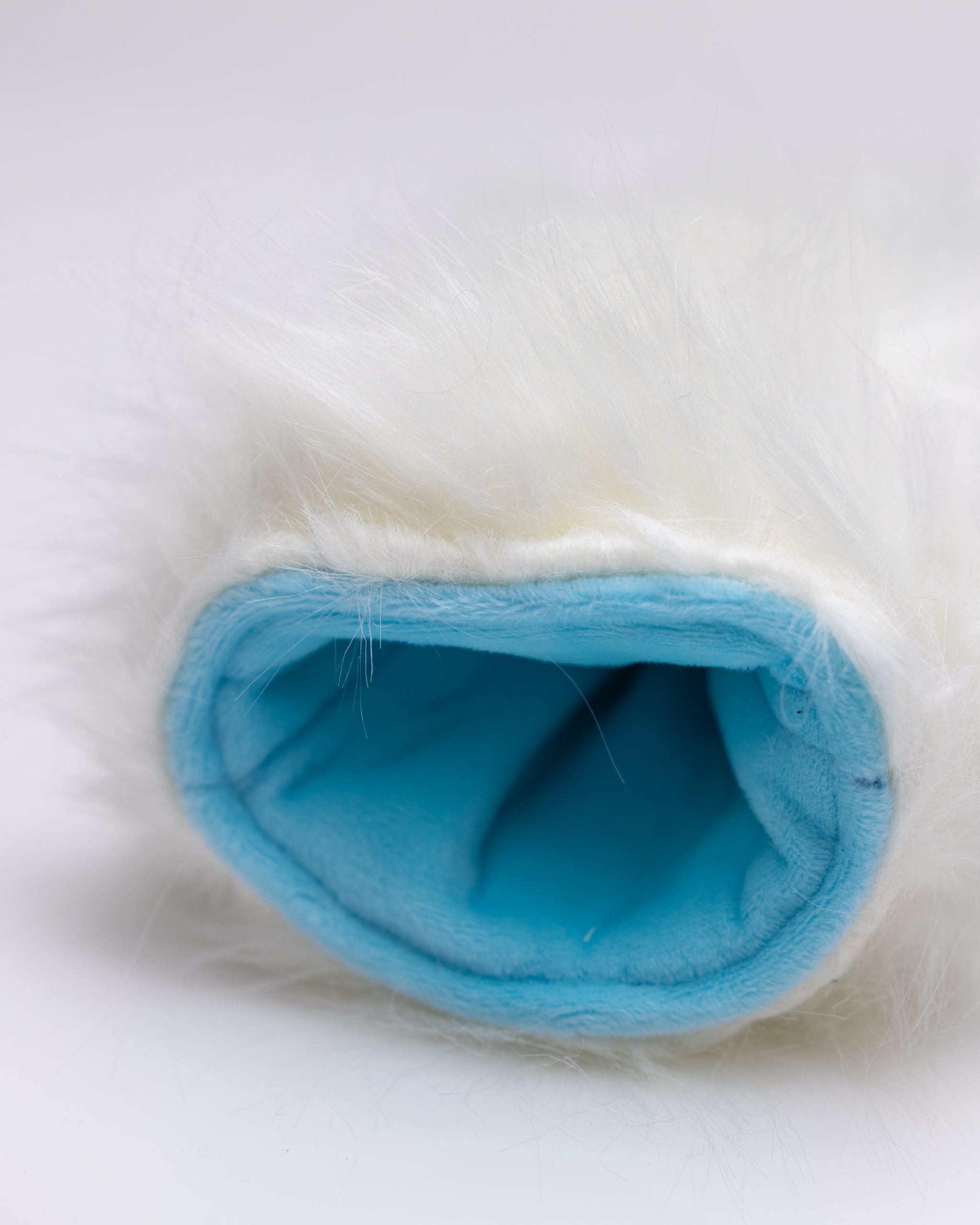 Soft, white fur hybrid golf headcover with a blue interior, designed to protect clubs while adding a fun style on the course.