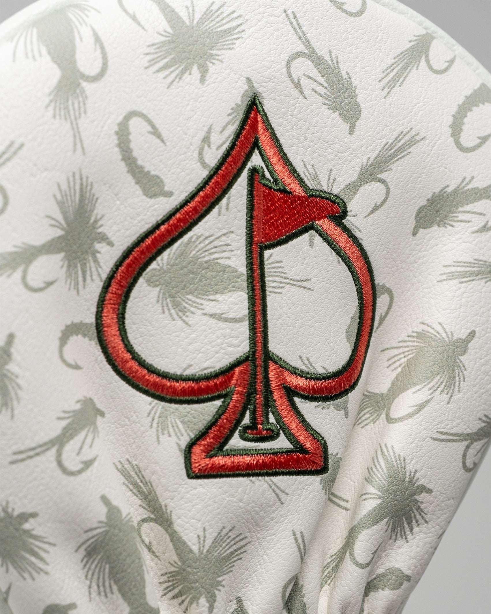 Trout driver cover featuring a stylish spade design with a red flag, perfect for golfers seeking unique accessories.