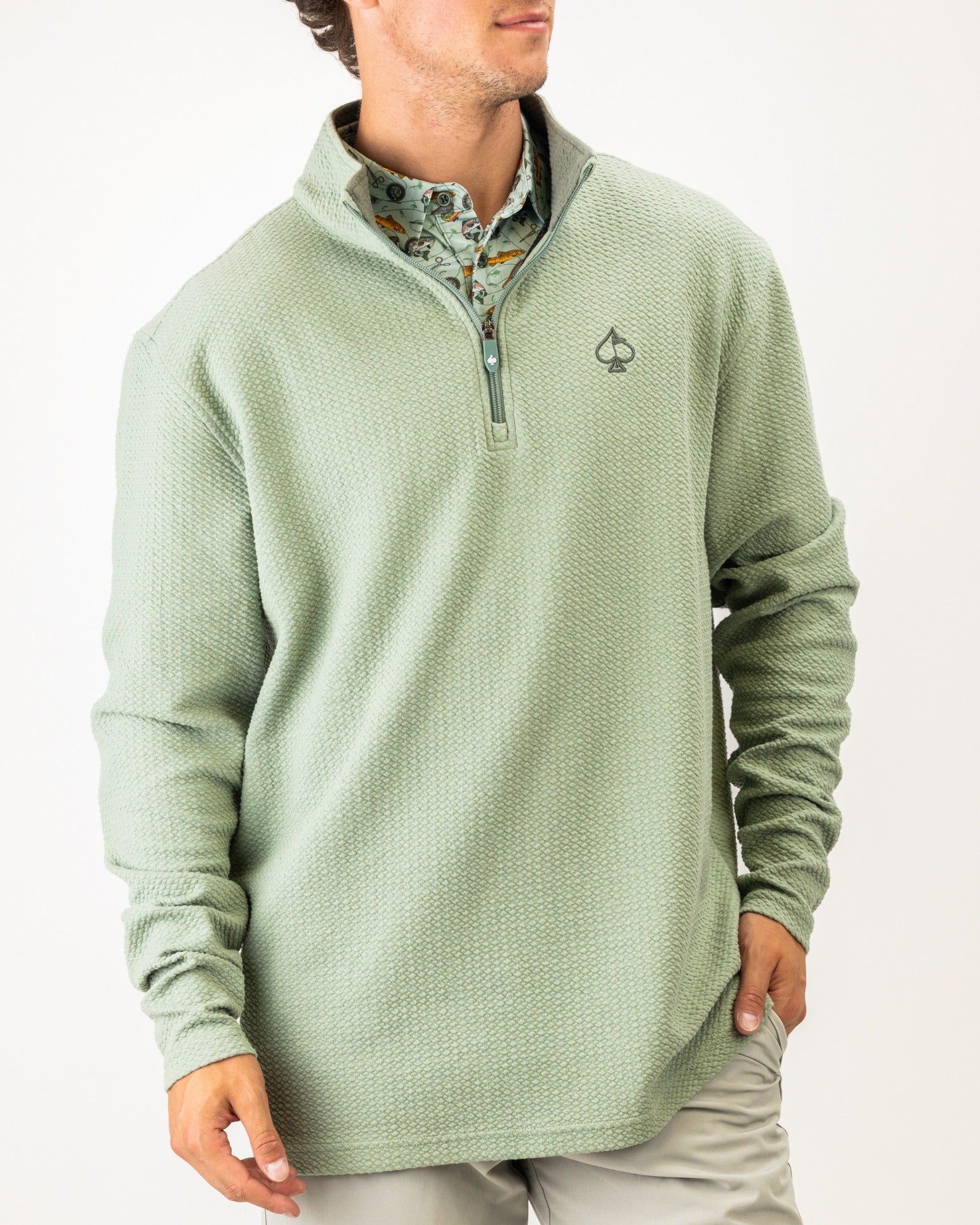 Olive green waffle knit pullover with a quarter zip and logo, perfect for stylish comfort on the golf course.