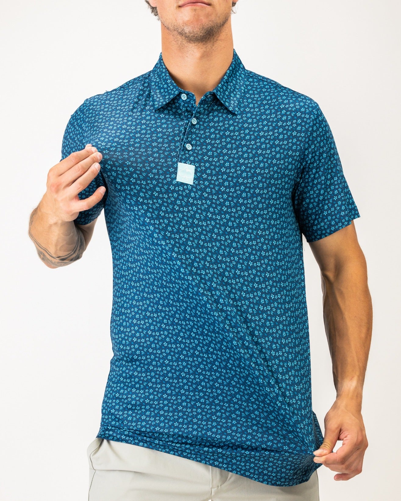 Men's blue polo shirt featuring a micro floral pattern, designed for a stylish and comfortable golf experience.