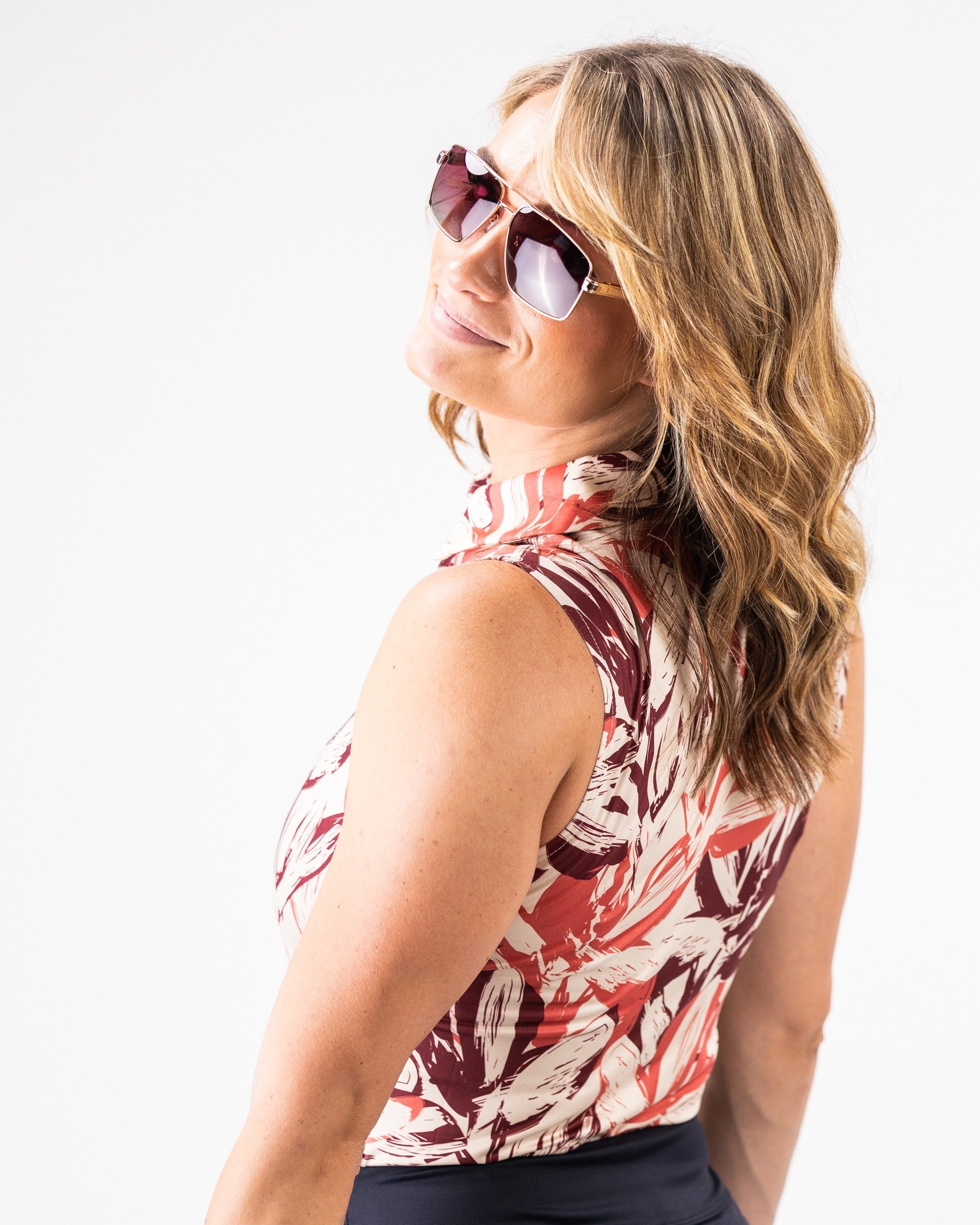 Stylish woman wearing a women's brushed floral top with sunglasses, showcasing a vibrant floral pattern.