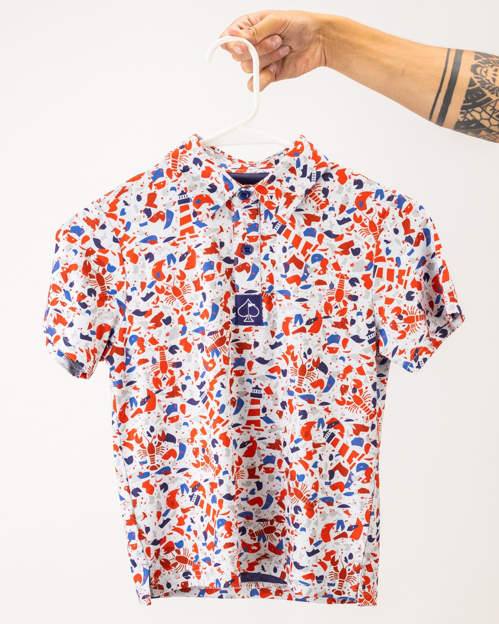 Youth Lobster Shatter shirt featuring a vibrant red, blue, and white abstract pattern, perfect for stylish young golfers.