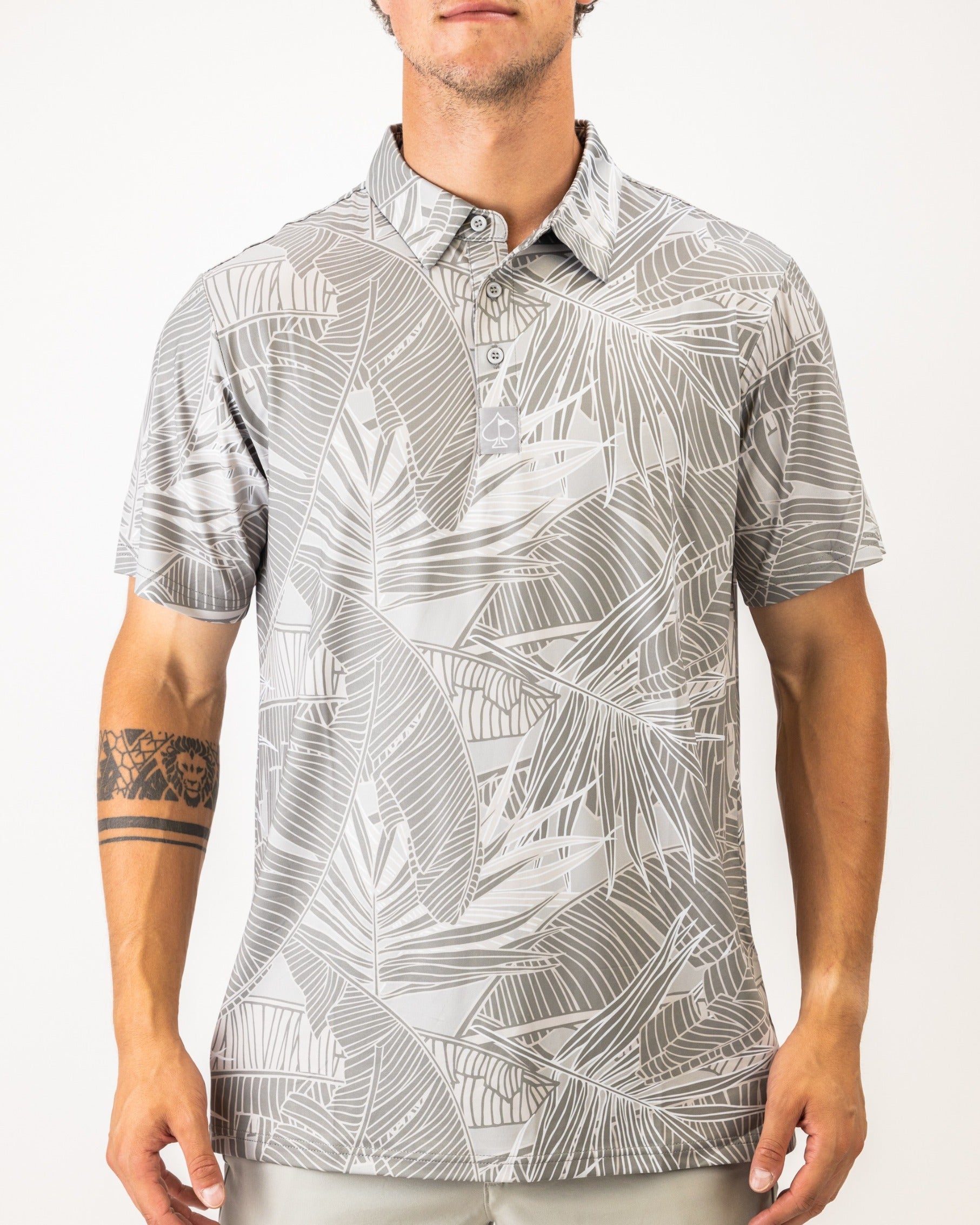 Men's short-sleeve golf shirt featuring a bold gray palm leaf pattern, designed for a stylish look on the course.