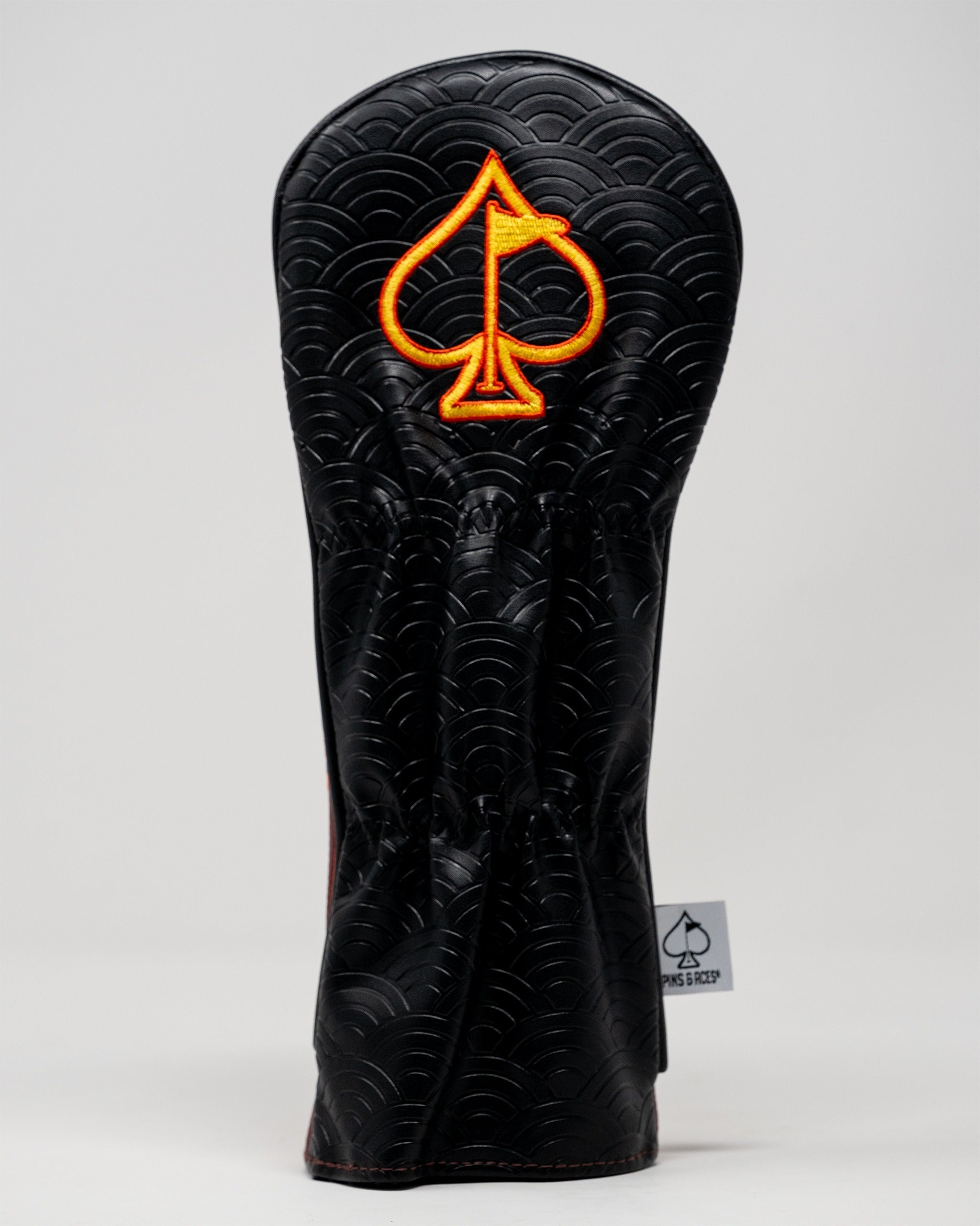 Bold black fairway cover featuring a vibrant orange spade logo, designed for golfers seeking standout accessories.