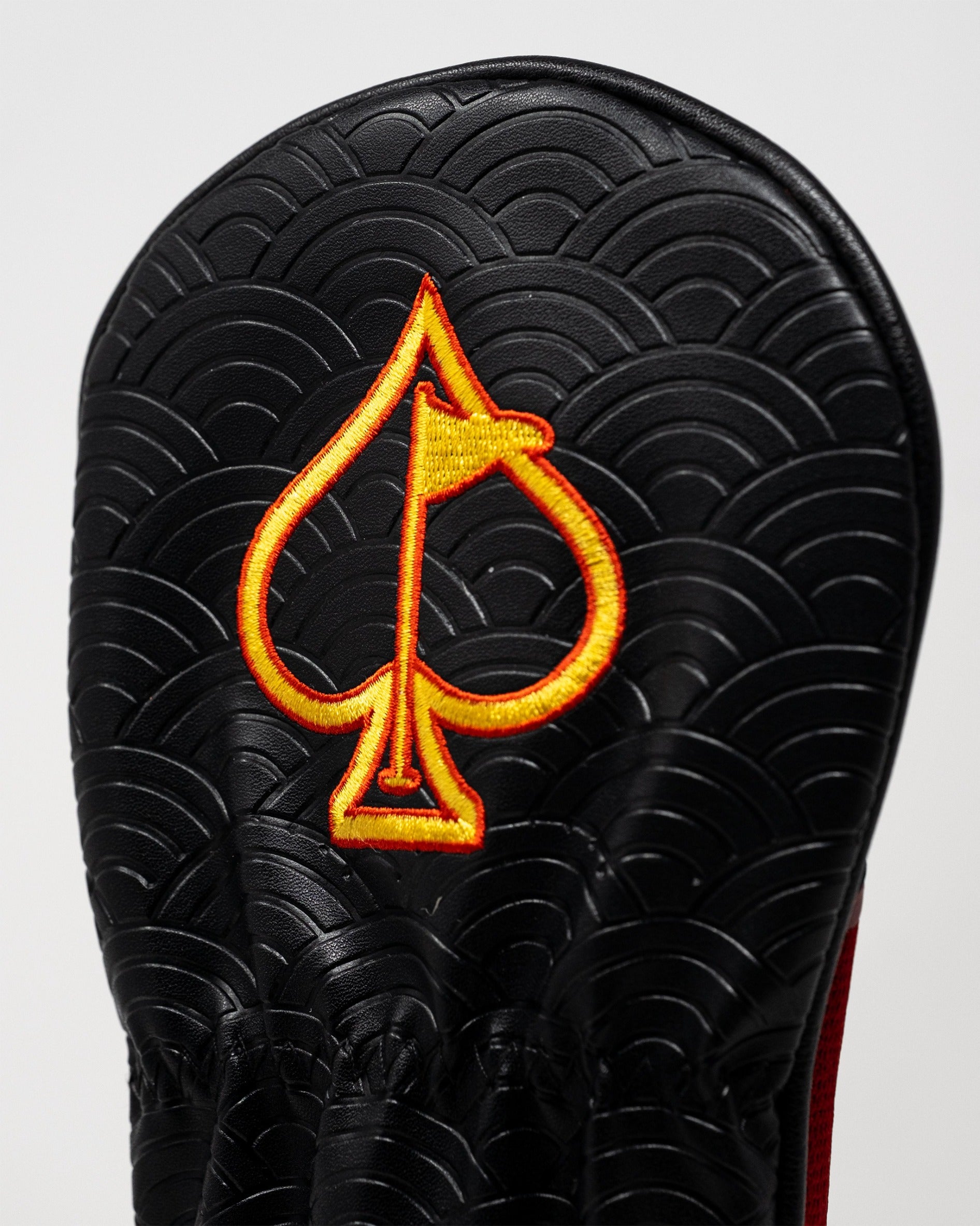 Bold black fairway cover featuring a vibrant red and yellow spade emblem, designed for golfers who want to stand out.