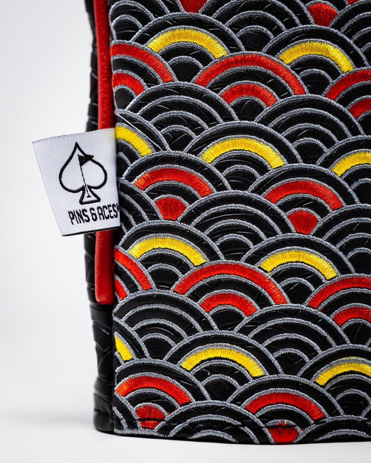 Bold driver cover featuring a vibrant dragon scale pattern in red, yellow, and black, perfect for standout golf style.