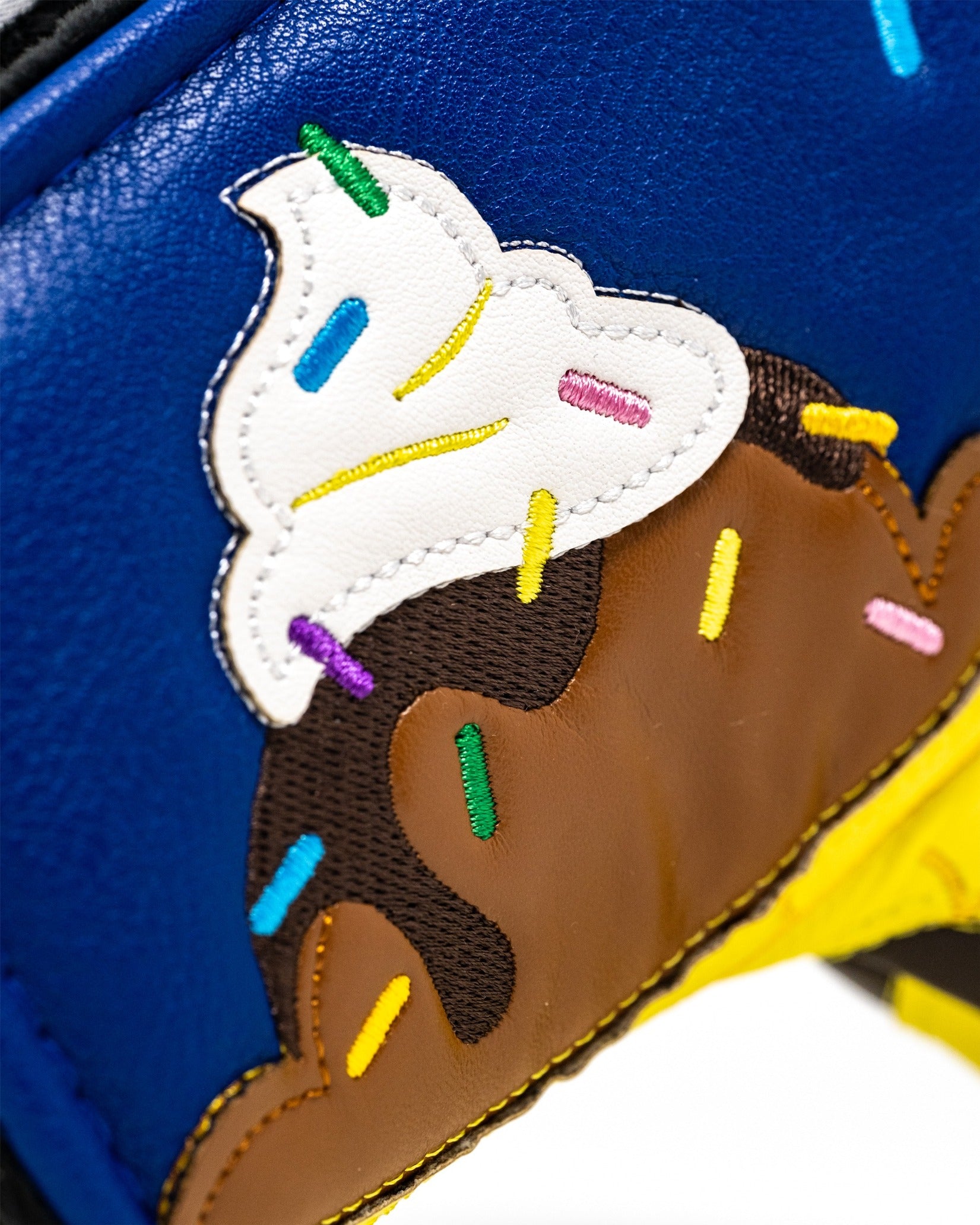 Colorful blade putter cover featuring a banana split design with embroidered ice cream and sprinkles on a blue background.