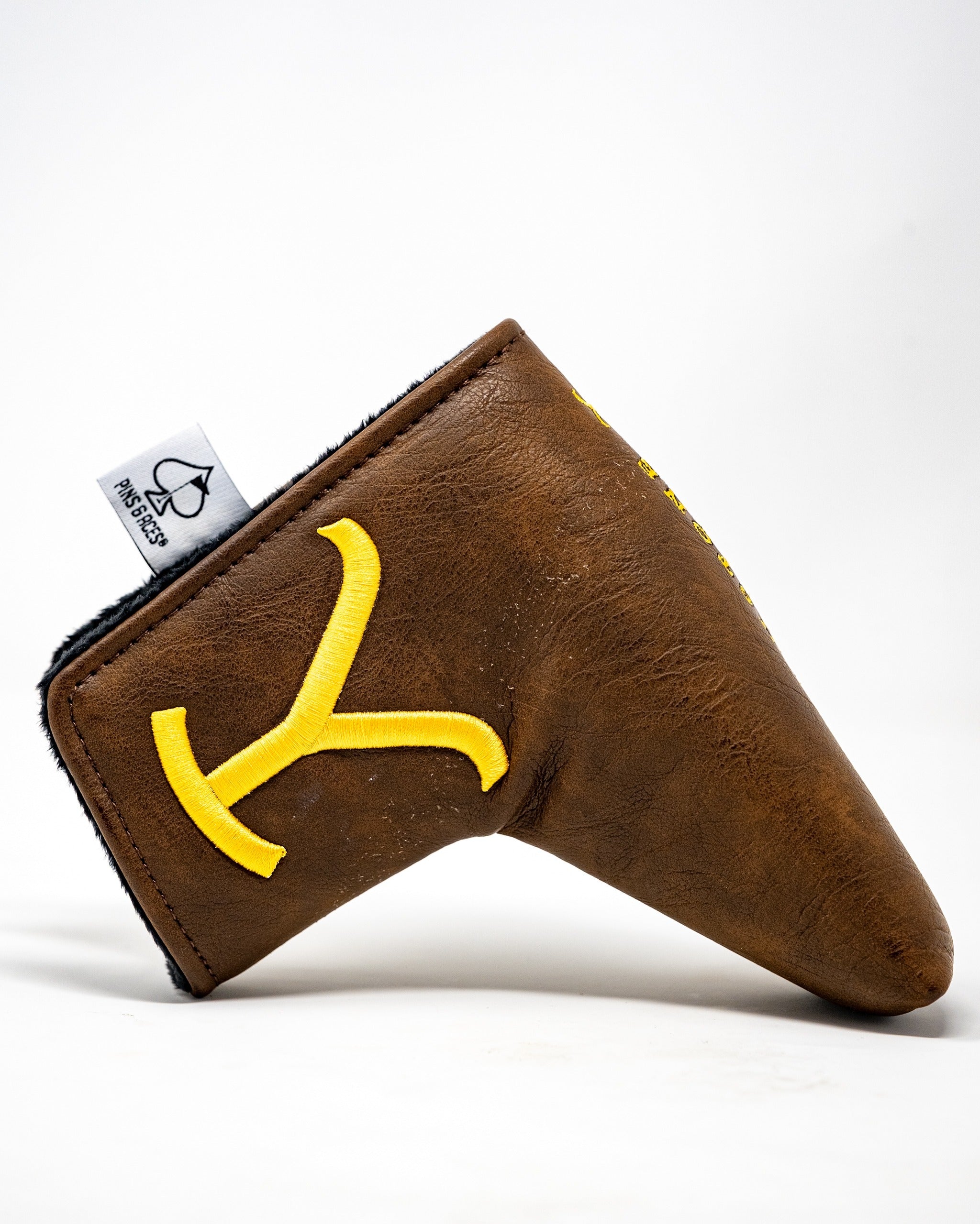 Brown leather blade putter cover featuring a bold yellow Yellowstone logo, designed for stylish golf protection.