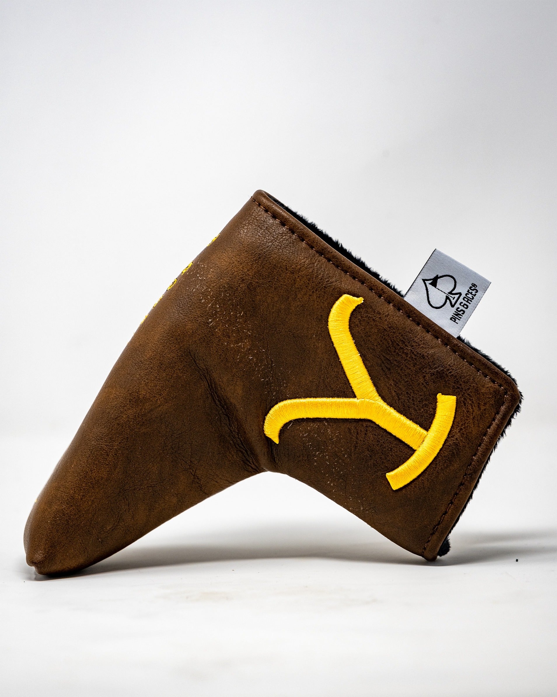 Yellowstone putter cover in brown leather with yellow logo, designed for blade putters, offering stylish protection.
