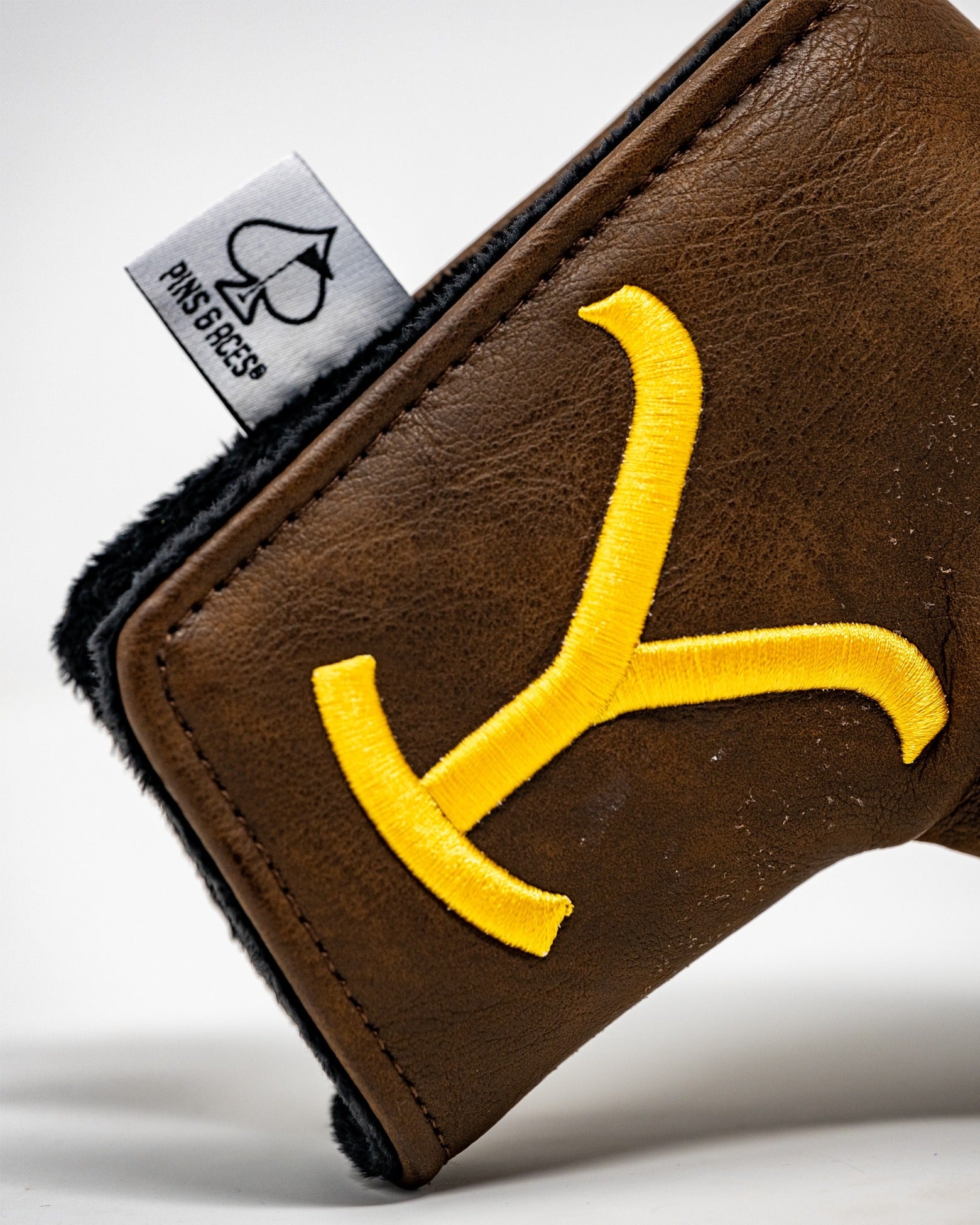 Yellowstone blade putter cover in brown leather with a yellow embroidered logo, featuring a soft black lining.