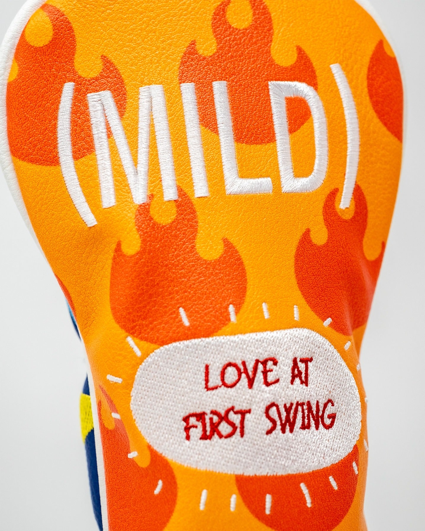 Bold hybrid golf headcover featuring a vibrant orange design with the word "(MILD)" and the phrase "LOVE AT FIRST SWING.