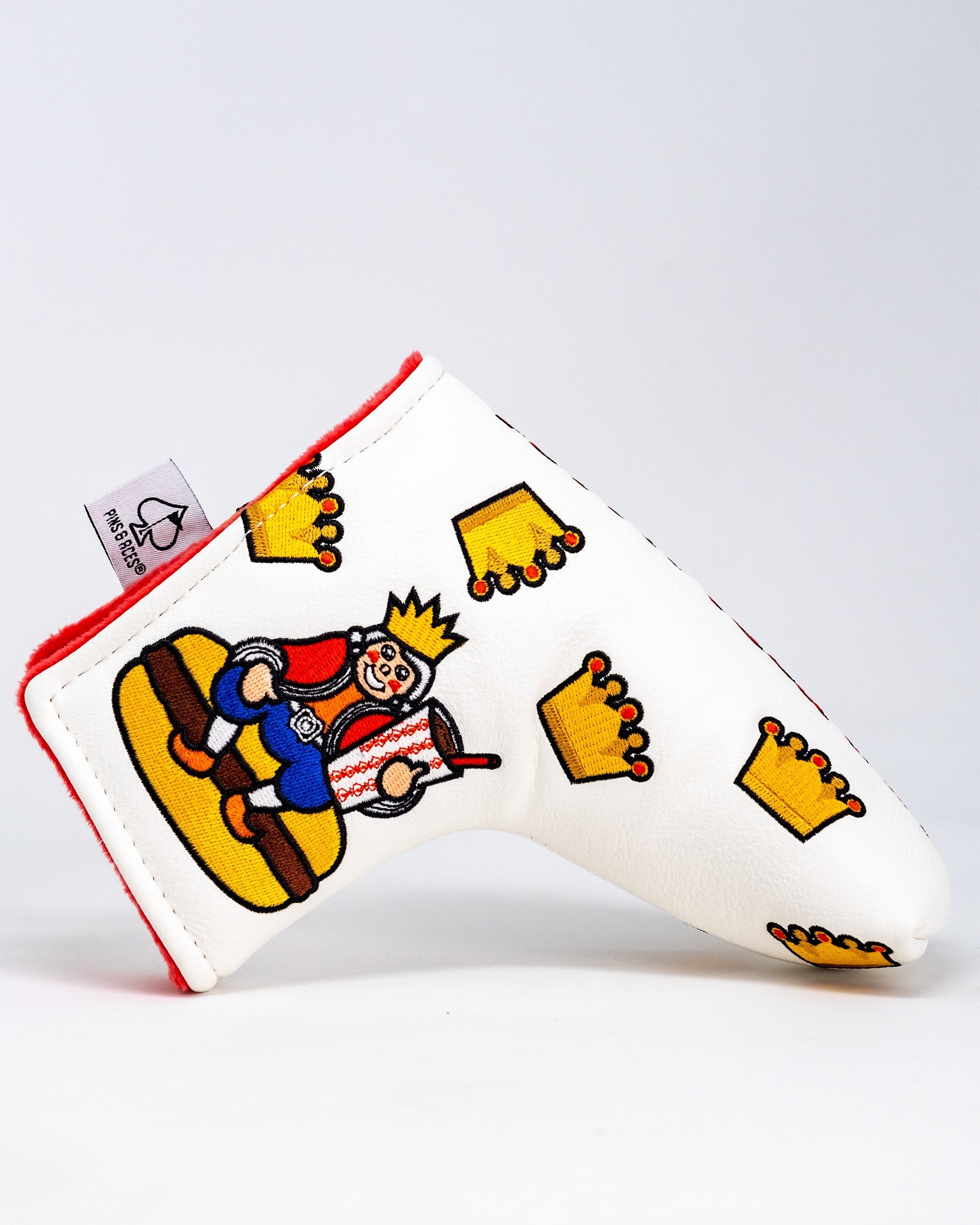 Unique white blade putter cover featuring a playful king design and crown motifs, perfect for stylish golfers.