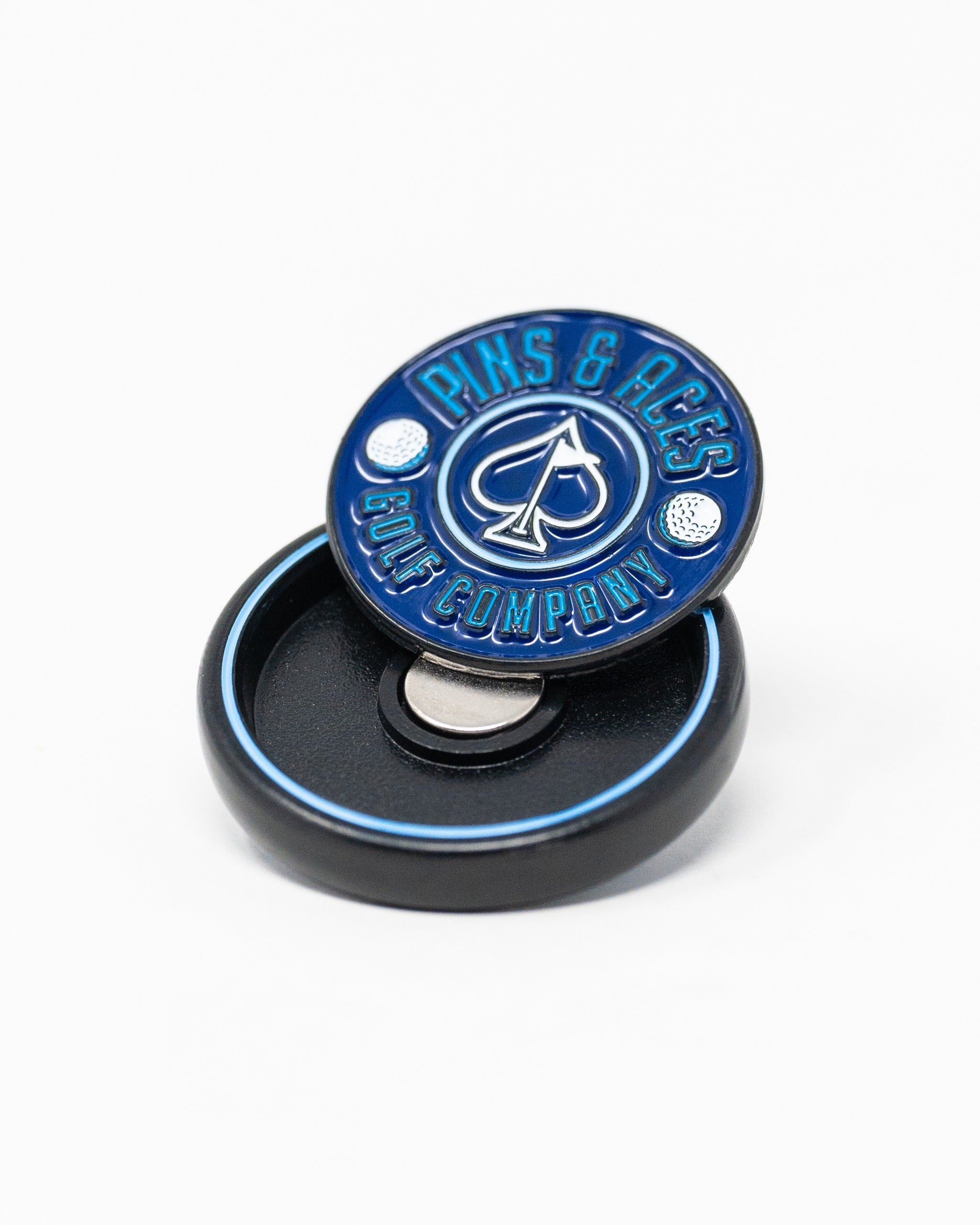 Navy pop-out medallion ball marker featuring a bold Pins and Aces logo, designed for stylish golf enthusiasts.
