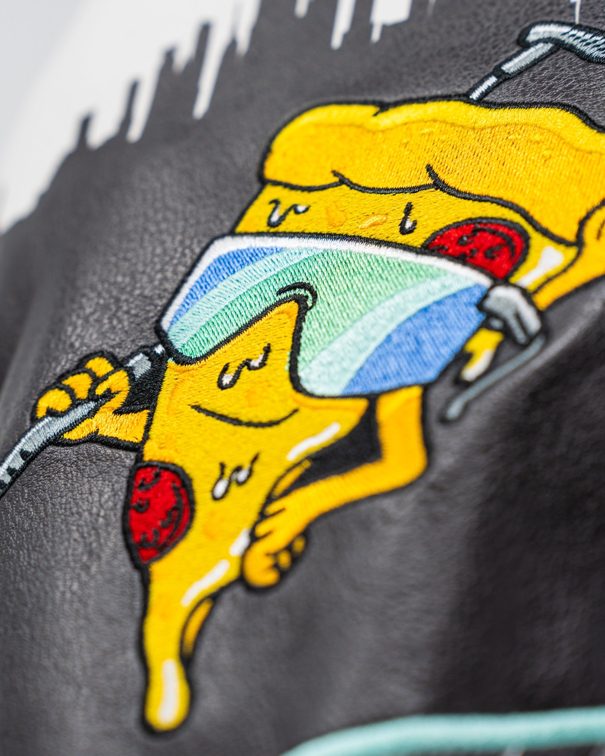Close-up of a pizza slice embroidered on a fairway cover, wearing sunglasses and holding a golf club, showcasing a fun design.