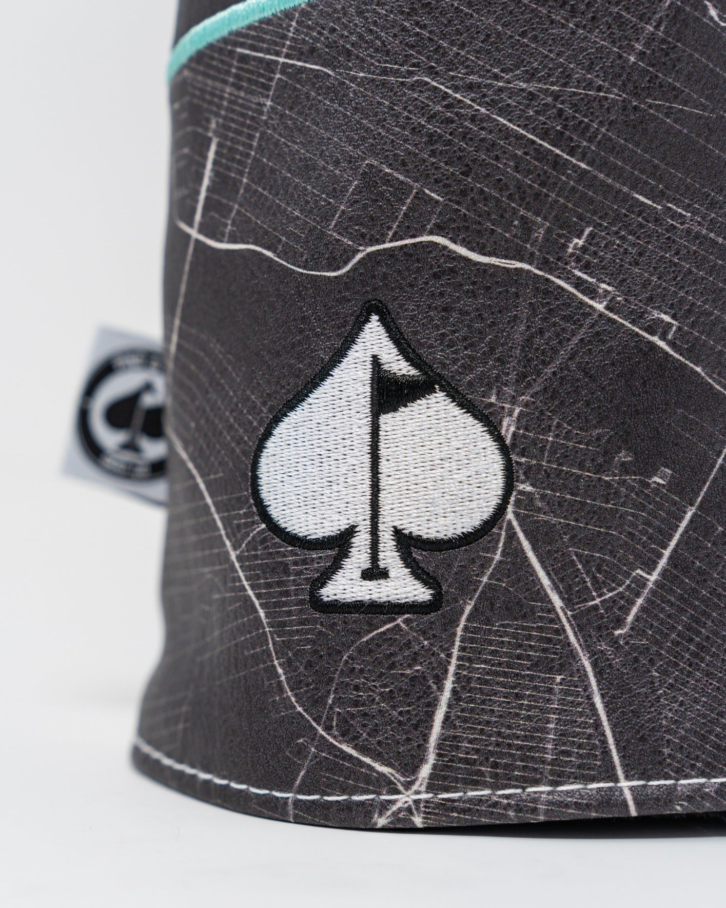 Shady Slice Fairway Cover featuring a spade logo on a textured black background with a map-like design.