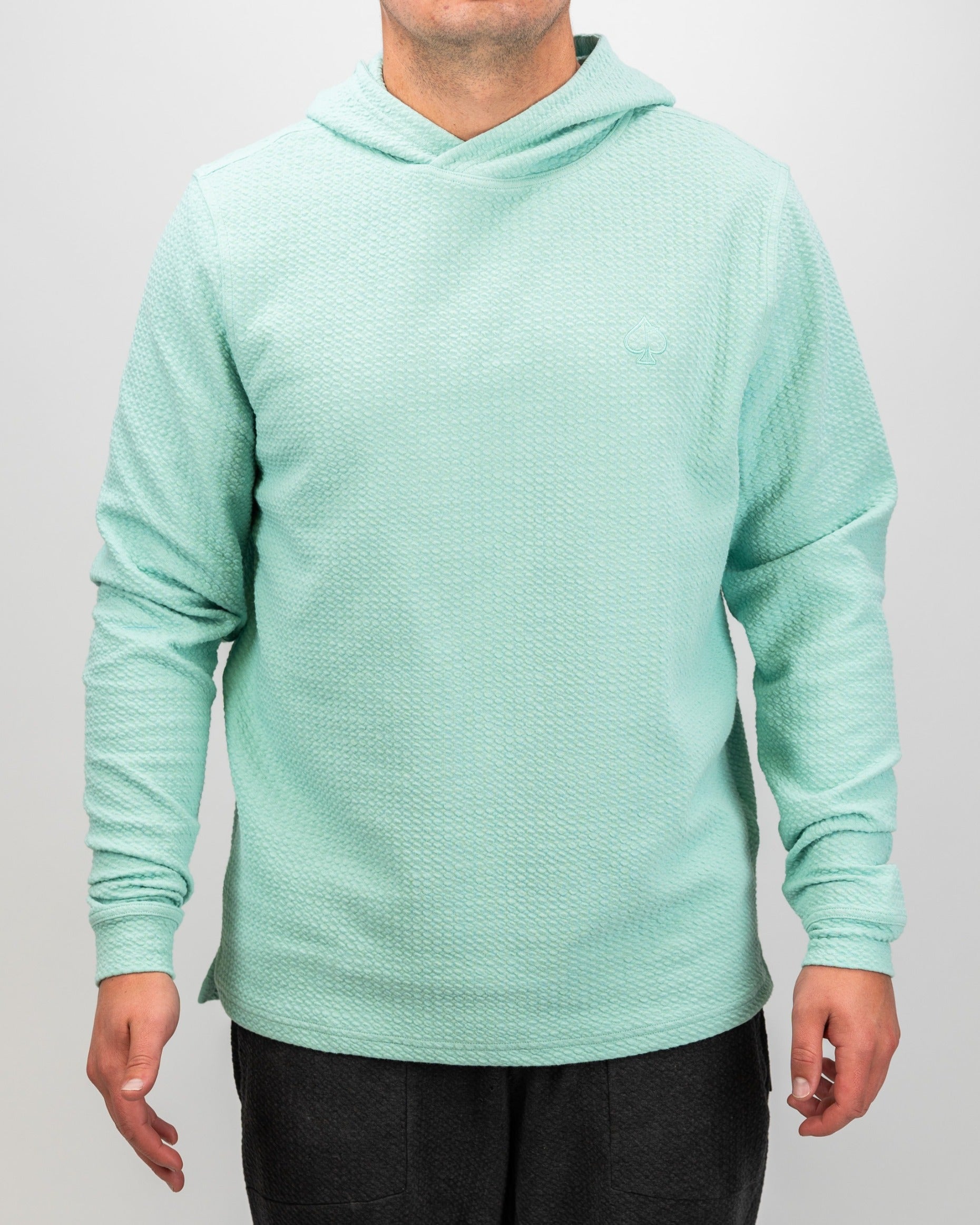 Bright mint waffle knit hoodie for golfers, featuring a relaxed fit and stylish design for comfort on and off the course.