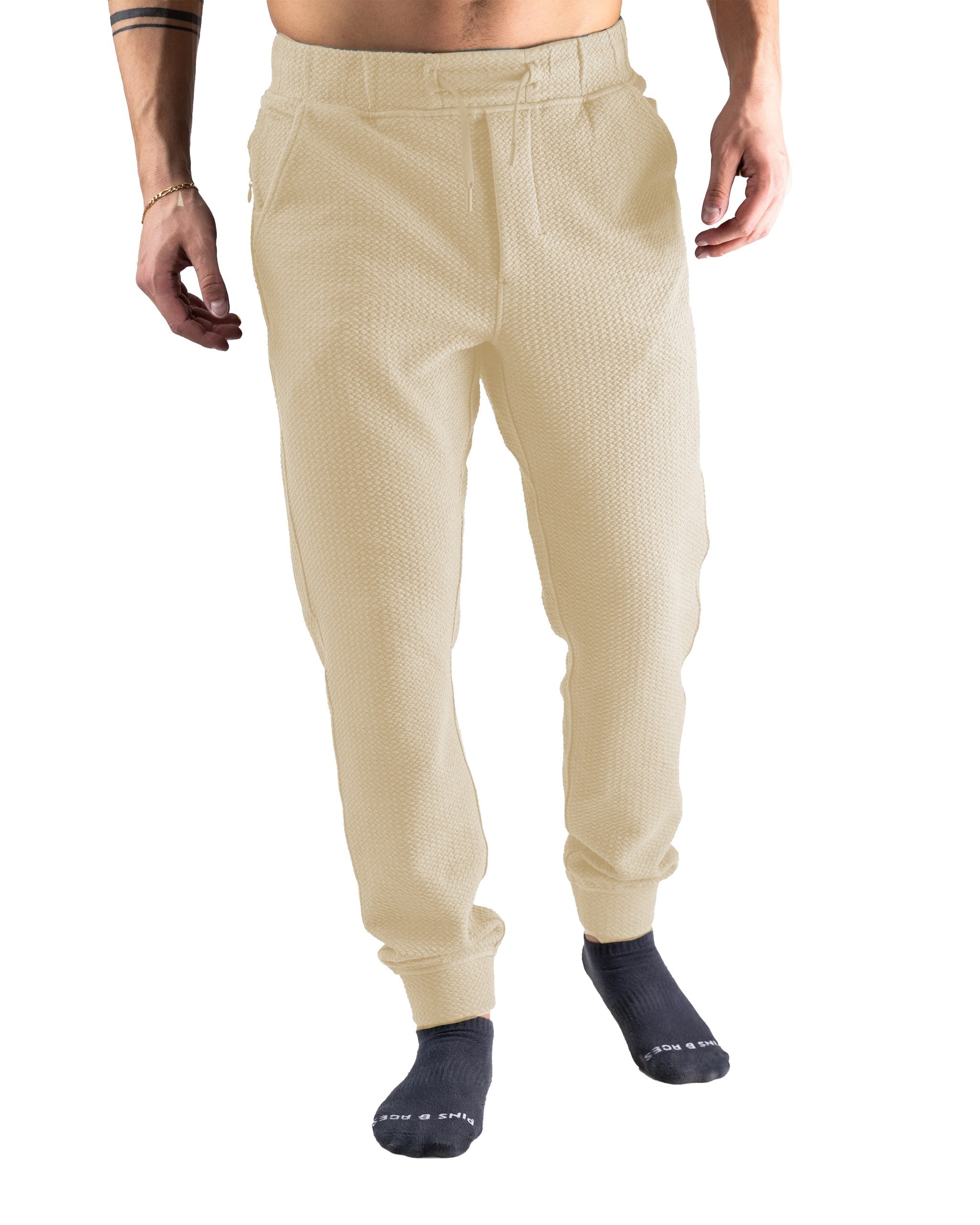 Cream waffle knit joggers designed for comfort and style, featuring an elastic waistband and tapered fit for a modern look.