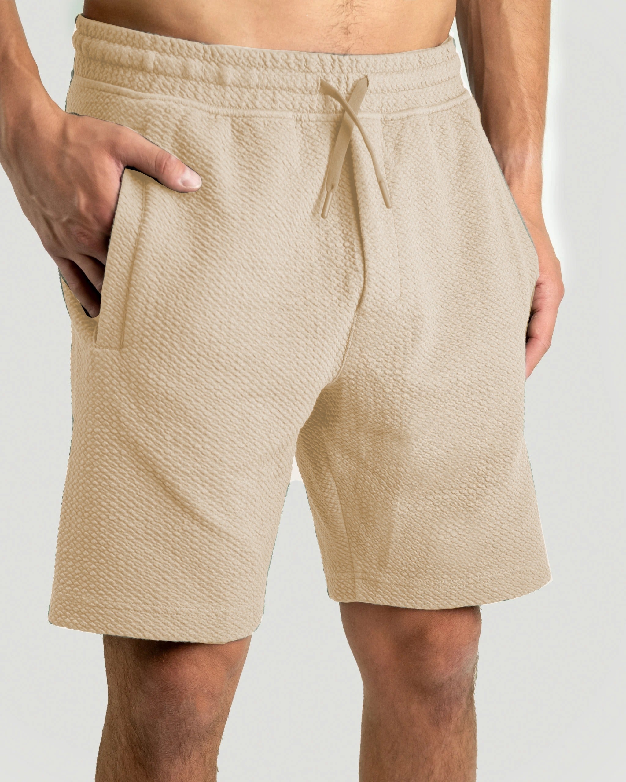 Cream waffle knit shorts featuring an elastic waistband and side pockets, ideal for stylish comfort on and off the golf course.