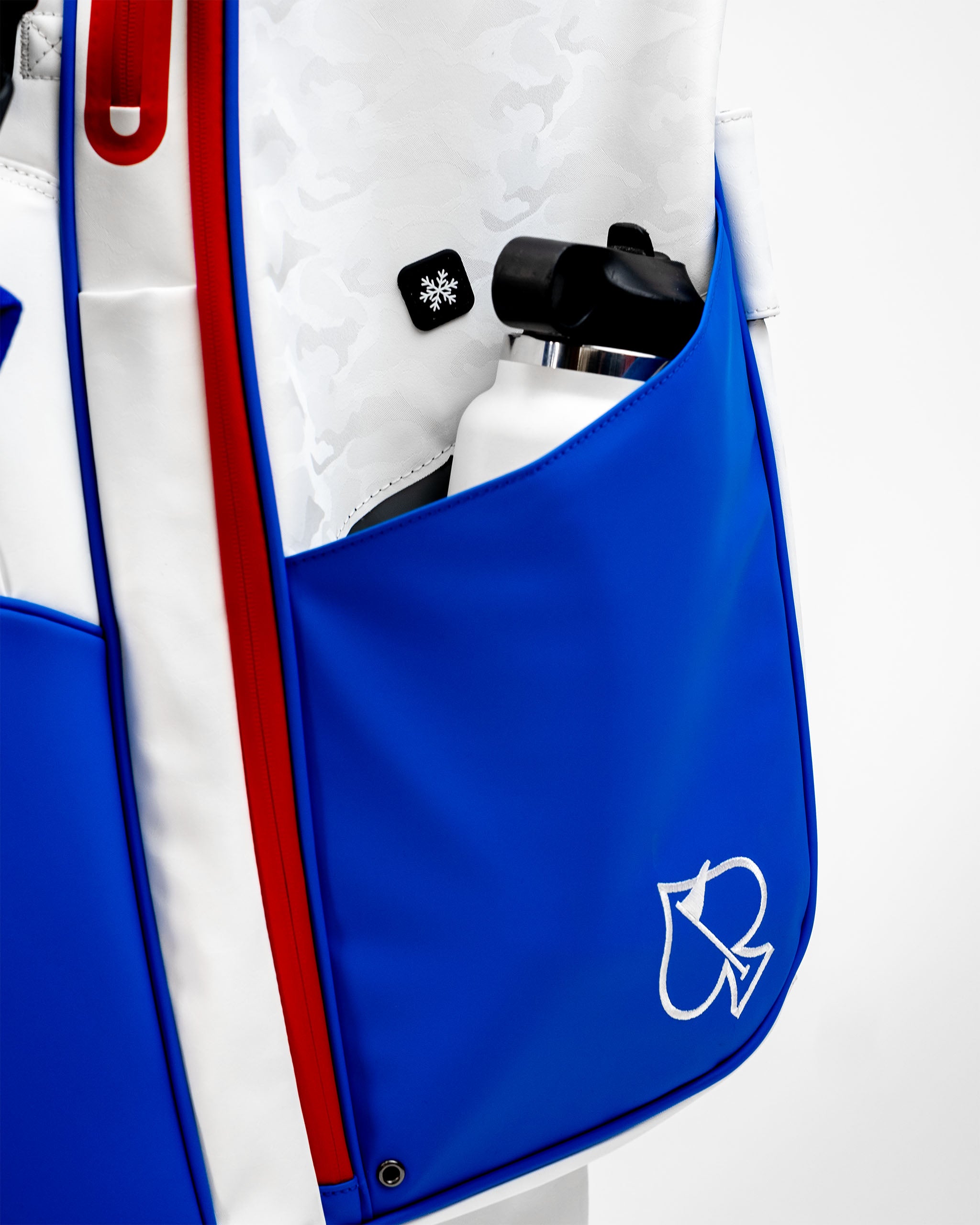 Close-up of a blue Player Preferred golf bag featuring a water bottle pocket and a stylish logo, showcasing bold design.