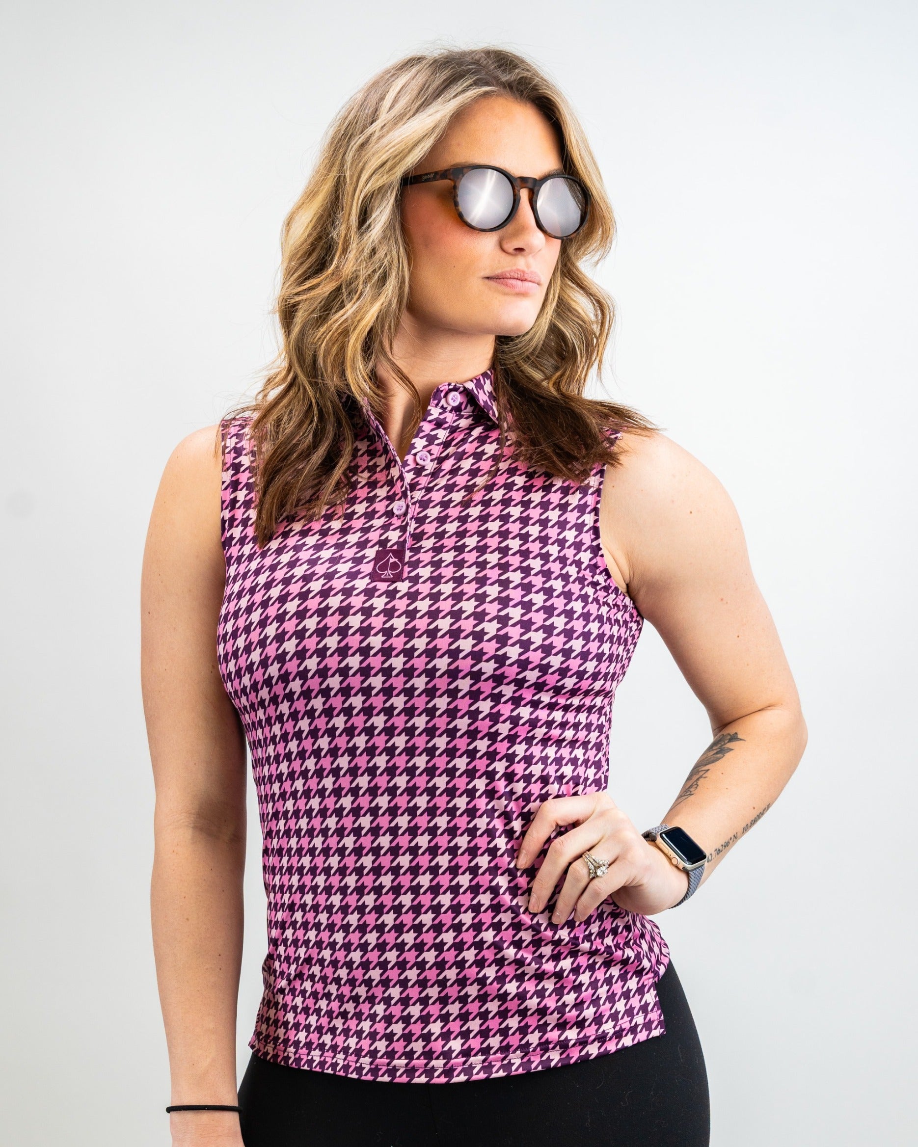 Stylish women's sleeveless polo in houndstooth raspberry pattern, perfect for a bold look on the golf course.