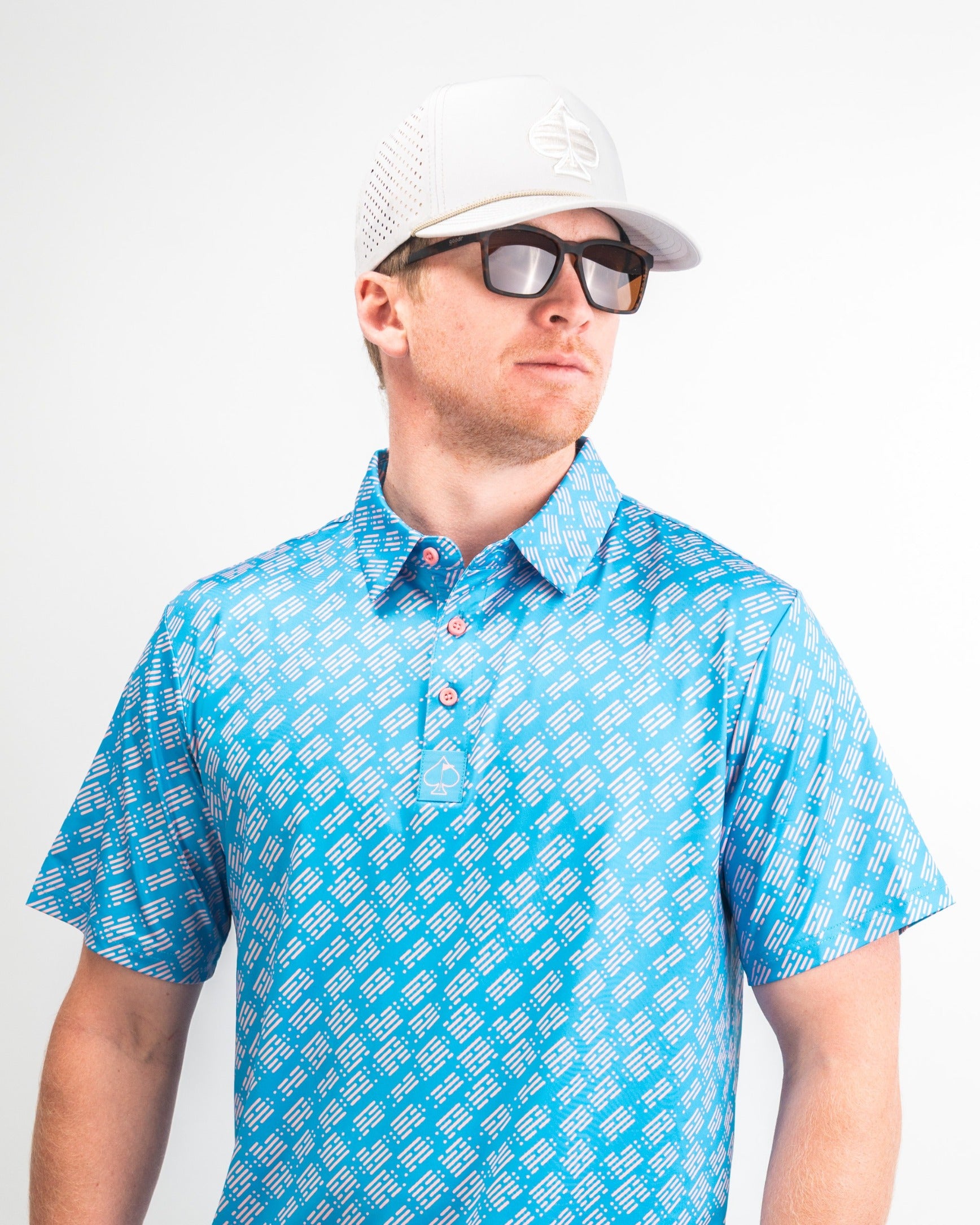 Stylish golfer wearing a blue patterned polo shirt and sunglasses, showcasing the Skyline Dash Blue golf apparel.