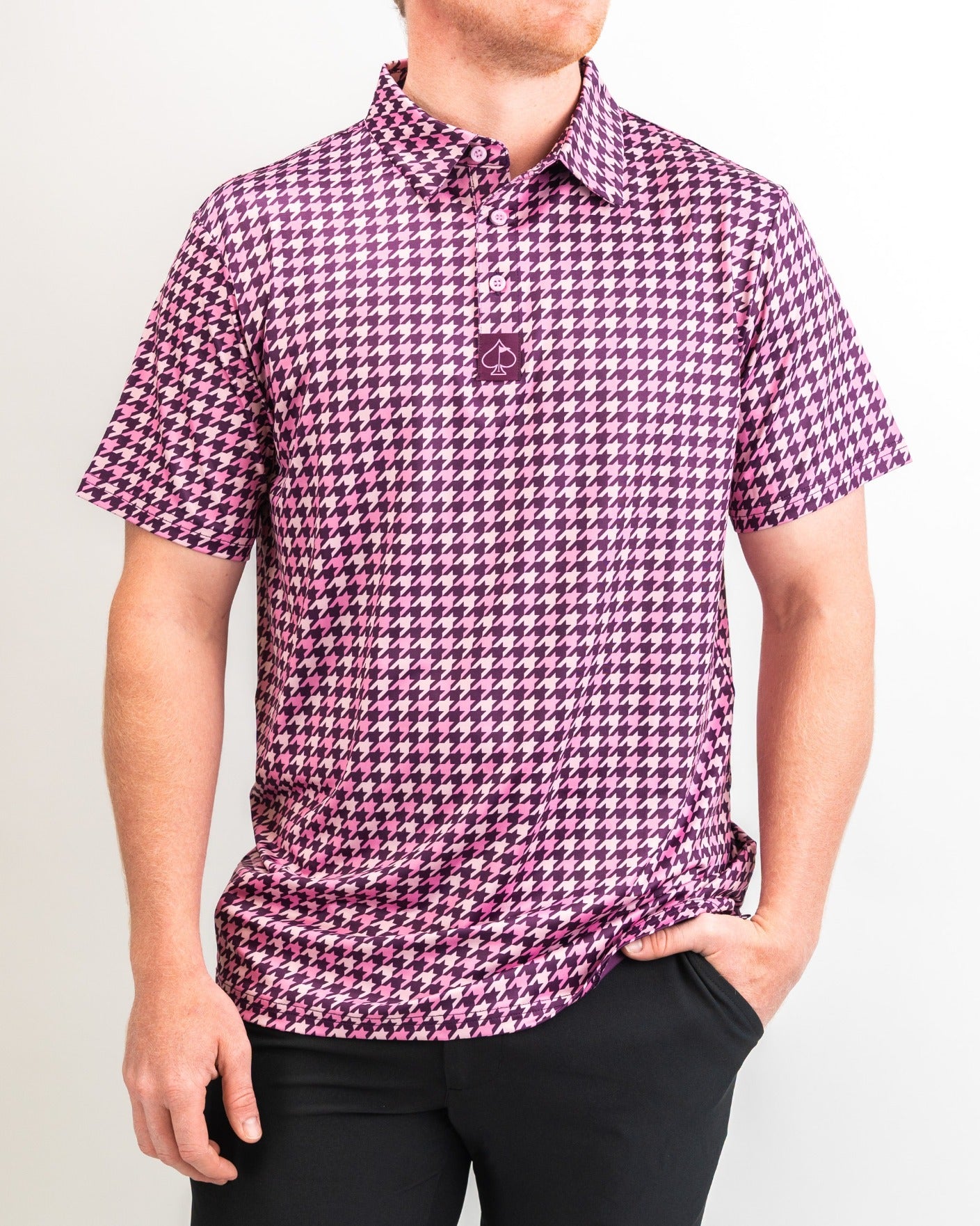 Bold houndstooth golf polo in raspberry pink, featuring a classic collar and short sleeves, perfect for stylish golfers.