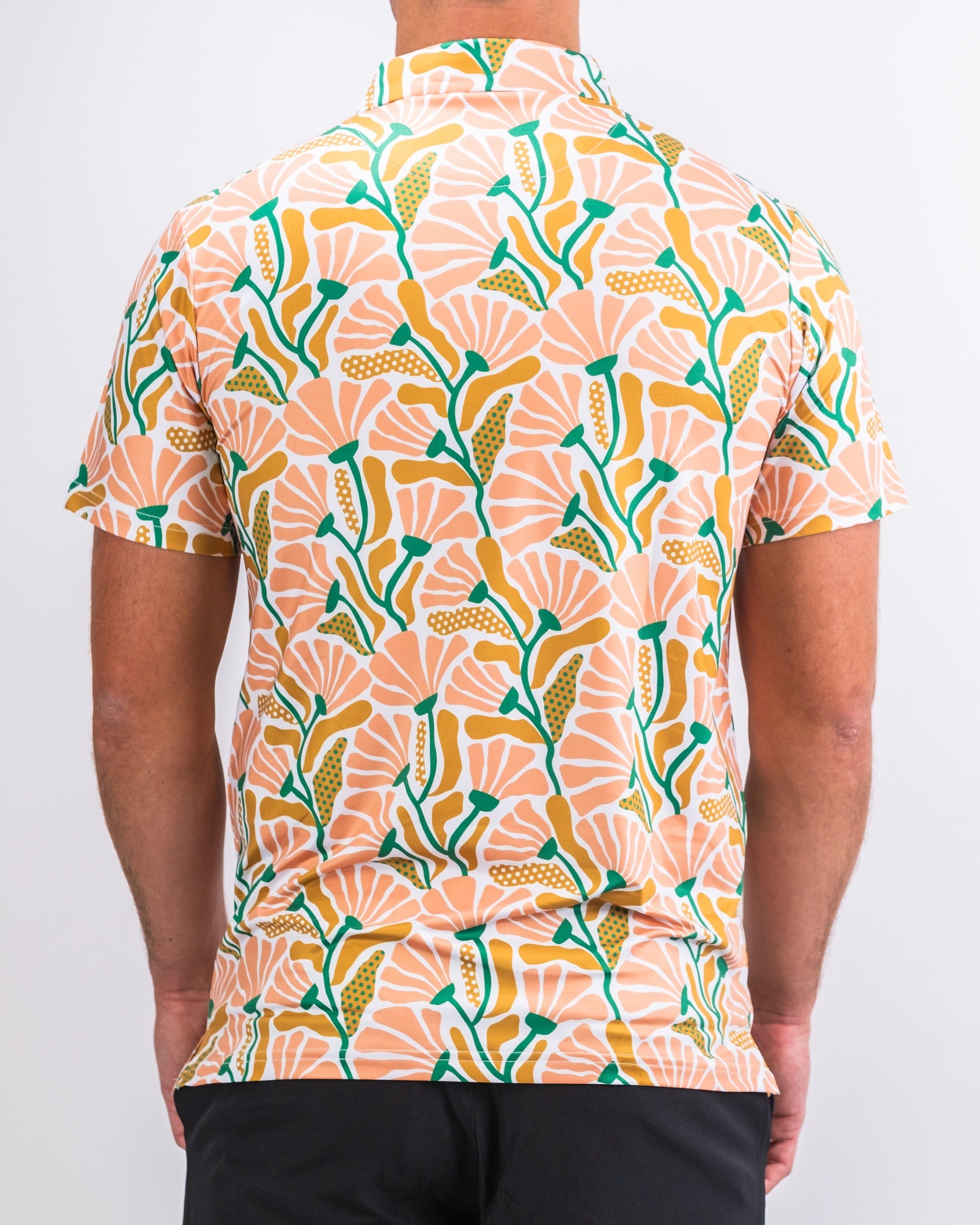 Men's short-sleeve shirt featuring a vibrant floral pattern in peach, green, and yellow, perfect for summer outings.