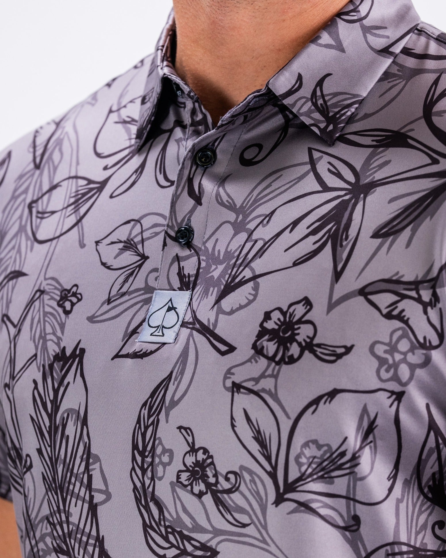 Men's golf polo shirt featuring a stylish floral pattern in shades of gray, designed for a bold look on the course.