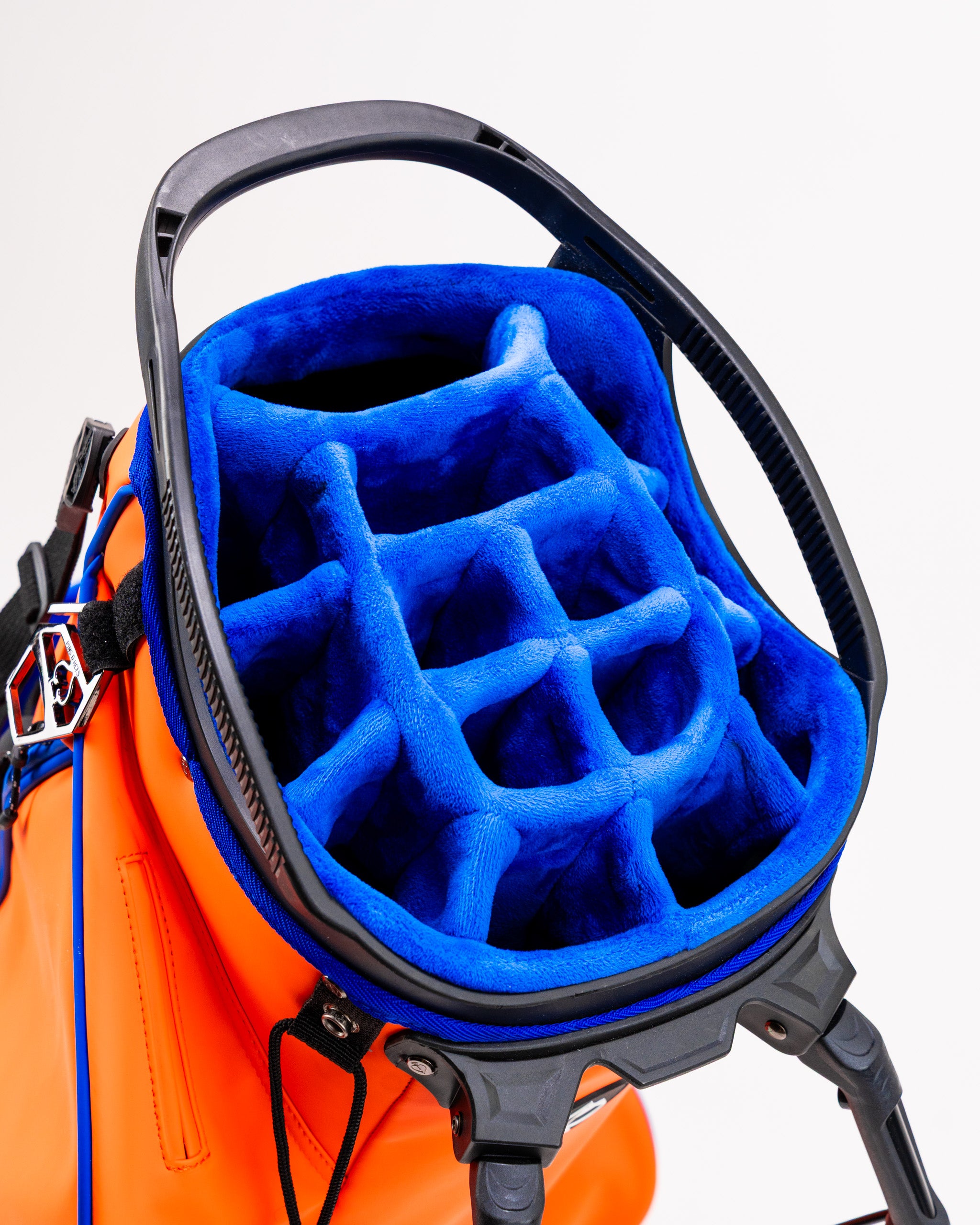 Top view of the Player Preferred Golf Bag in Orange Crush, featuring a blue padded interior with club dividers.