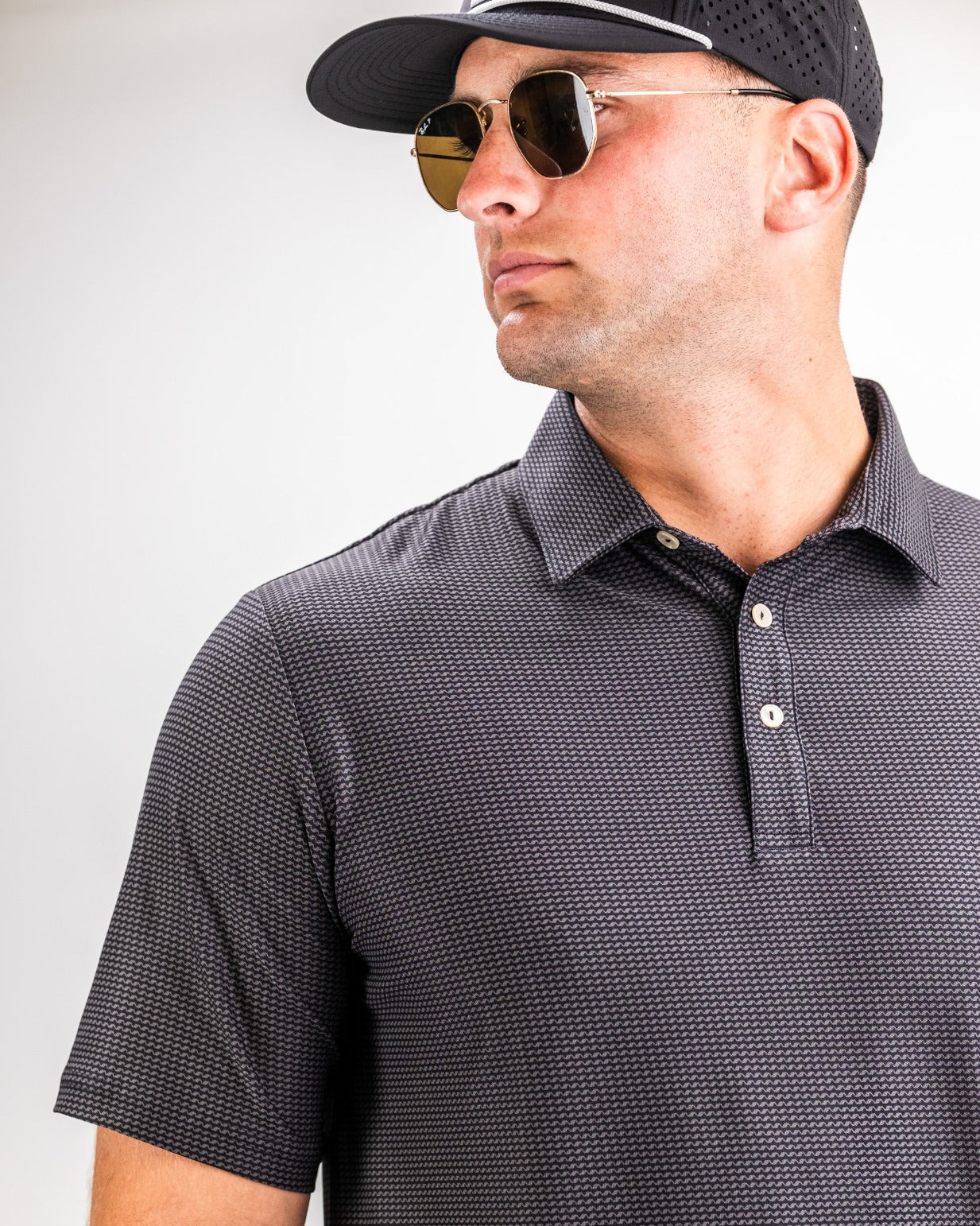 Stylish male model wearing the Player Preferred Polo in Night Wave, showcasing a modern design and sleek fit.