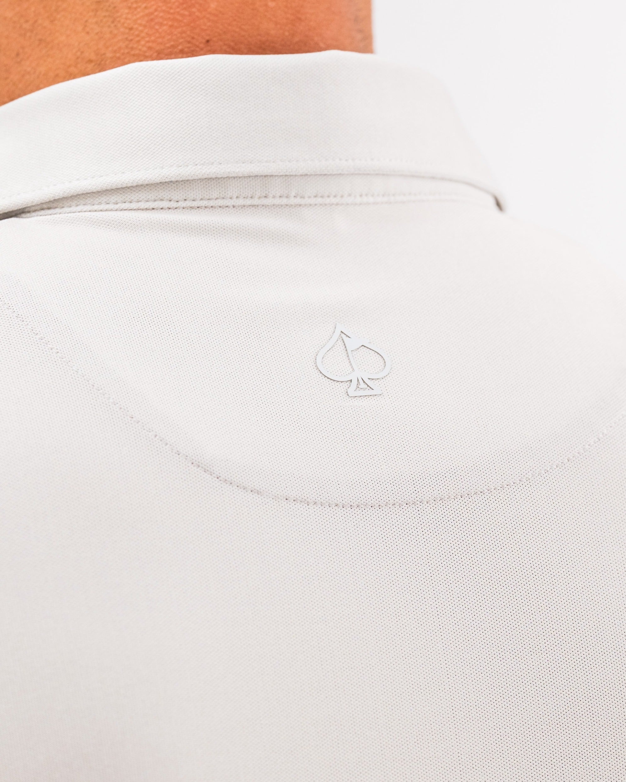 Light gray Player Preferred Polo featuring a subtle spade logo on the back collar, designed for stylish golfers.
