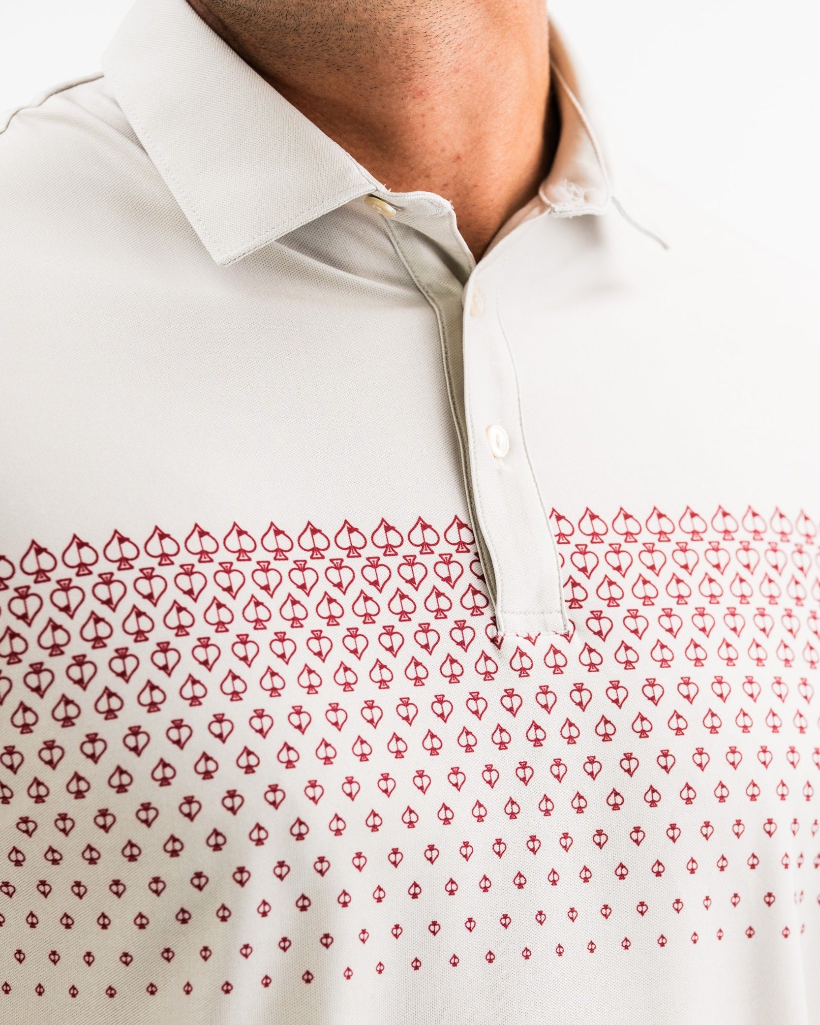Light-colored polo shirt featuring a spade fade design in red, perfect for golfers seeking stylish performance on the course.