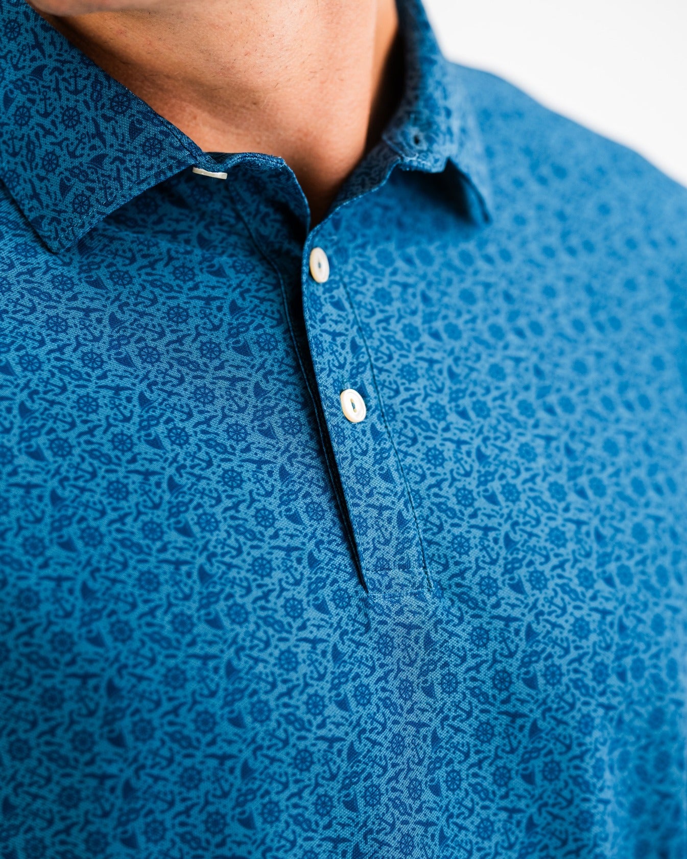Close-up of a blue patterned polo shirt featuring a classic collar and button placket, designed for stylish golfers.