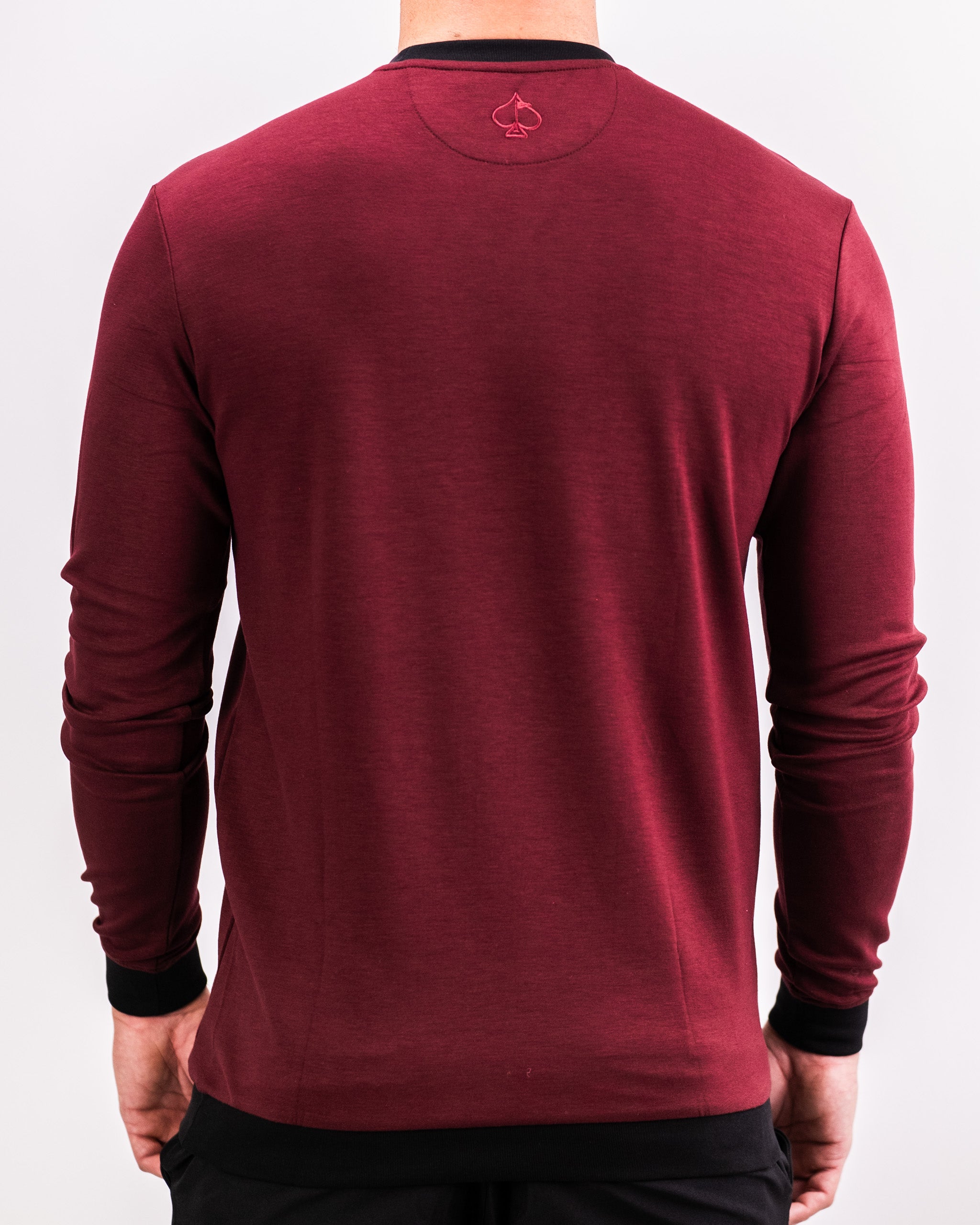 Men's merlot crewneck sweatshirt featuring a sleek design and contrasting black cuffs, perfect for stylish golf outings.