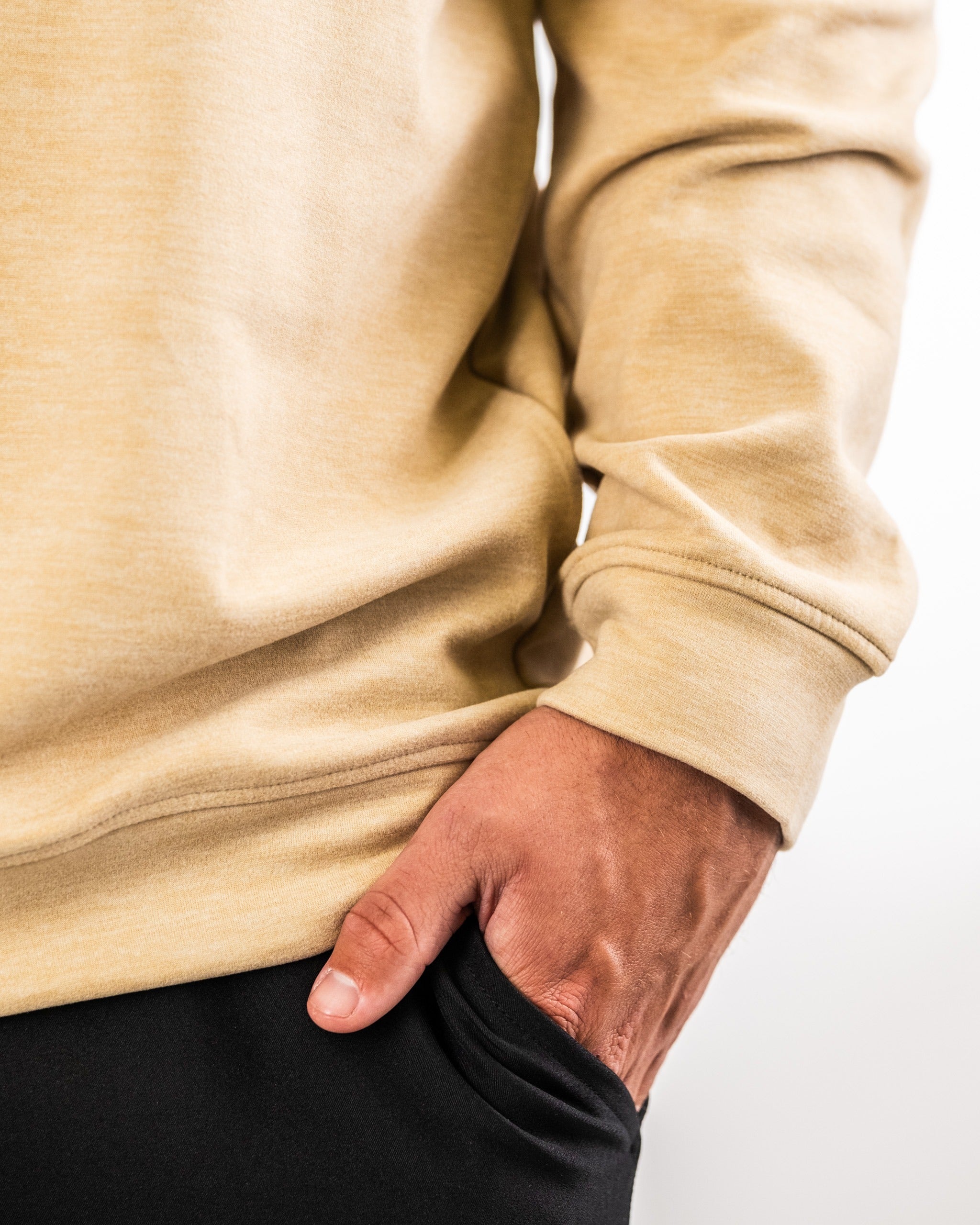 Close-up of a sand-colored Player Preferred pullover, featuring a relaxed fit and a hand in the pocket.