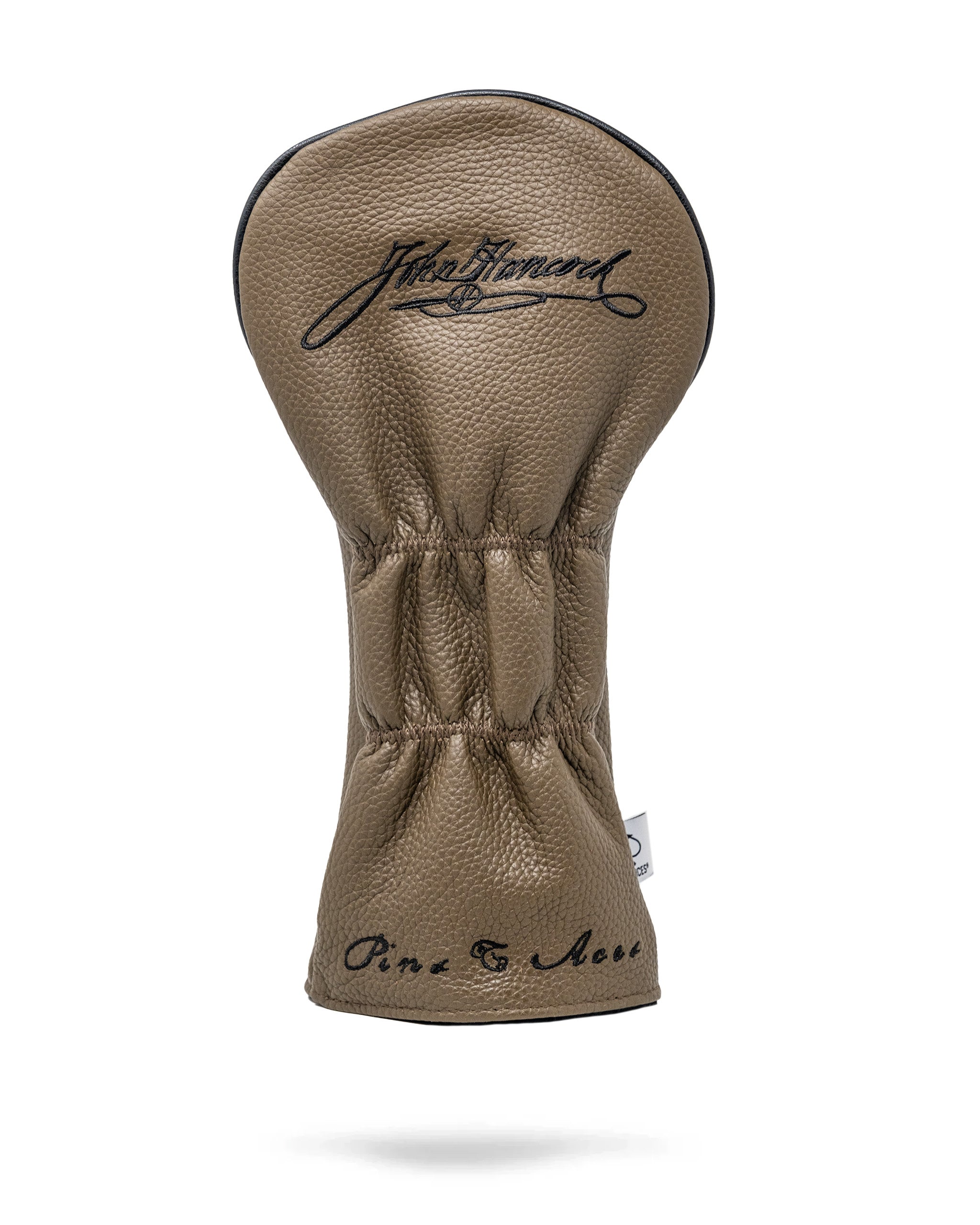 Stylish brown leather driver cover featuring a textured finish and elegant script logo for a bold golf statement.
