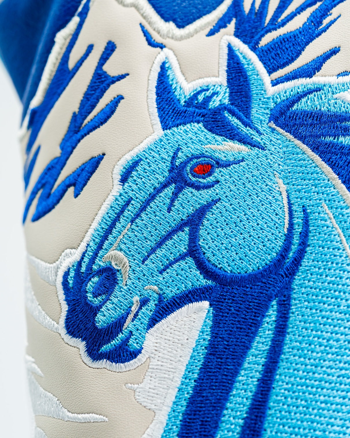 Bold blue horse driver cover featuring intricate embroidery and striking red eyes, perfect for standout golf style.