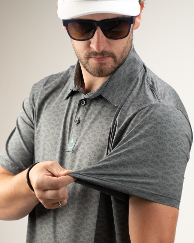 A golfer showcases the Large Mouth polo shirt, featuring a stylish pattern and a comfortable fit, perfect for the course.