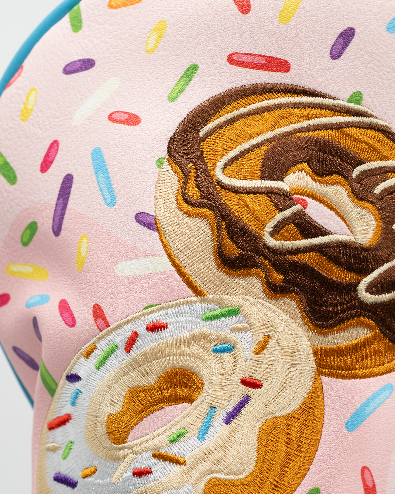 Colorful driver cover featuring embroidered donuts with sprinkles on a pastel pink background, perfect for stylish golfers.