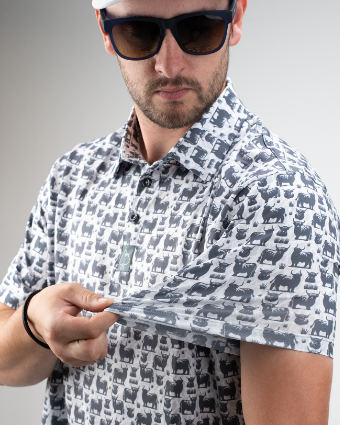 A golfer showcases a stylish shirt featuring a bold Highland cow pattern, highlighting its unique design and fit.
