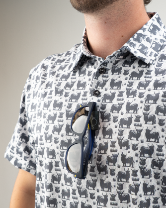 A close-up of a man wearing a Highland Cow patterned shirt with sunglasses resting on the collar.