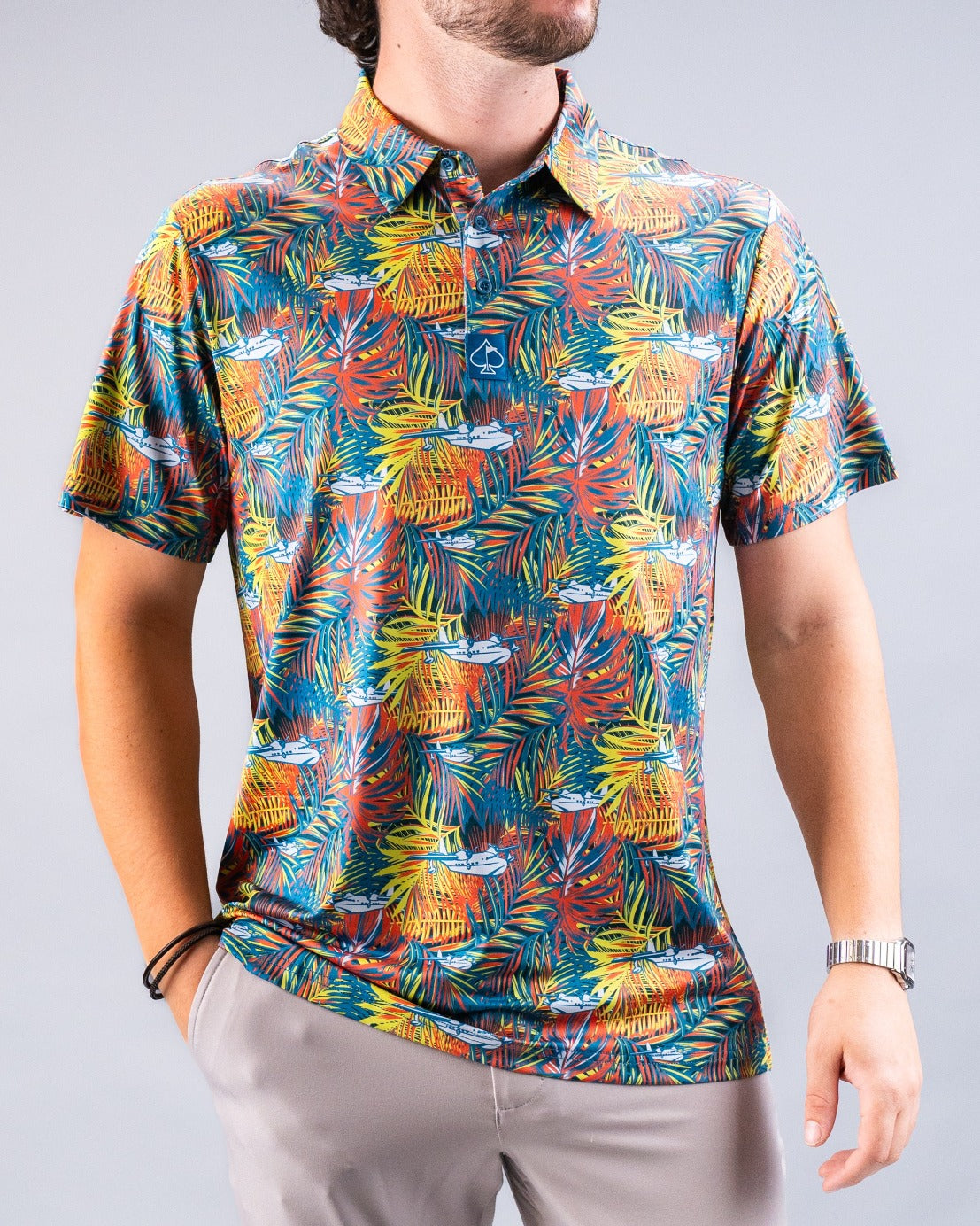 Colorful tropical print golf shirt featuring palm leaves and cocktail motifs, perfect for a vibrant day on the course.