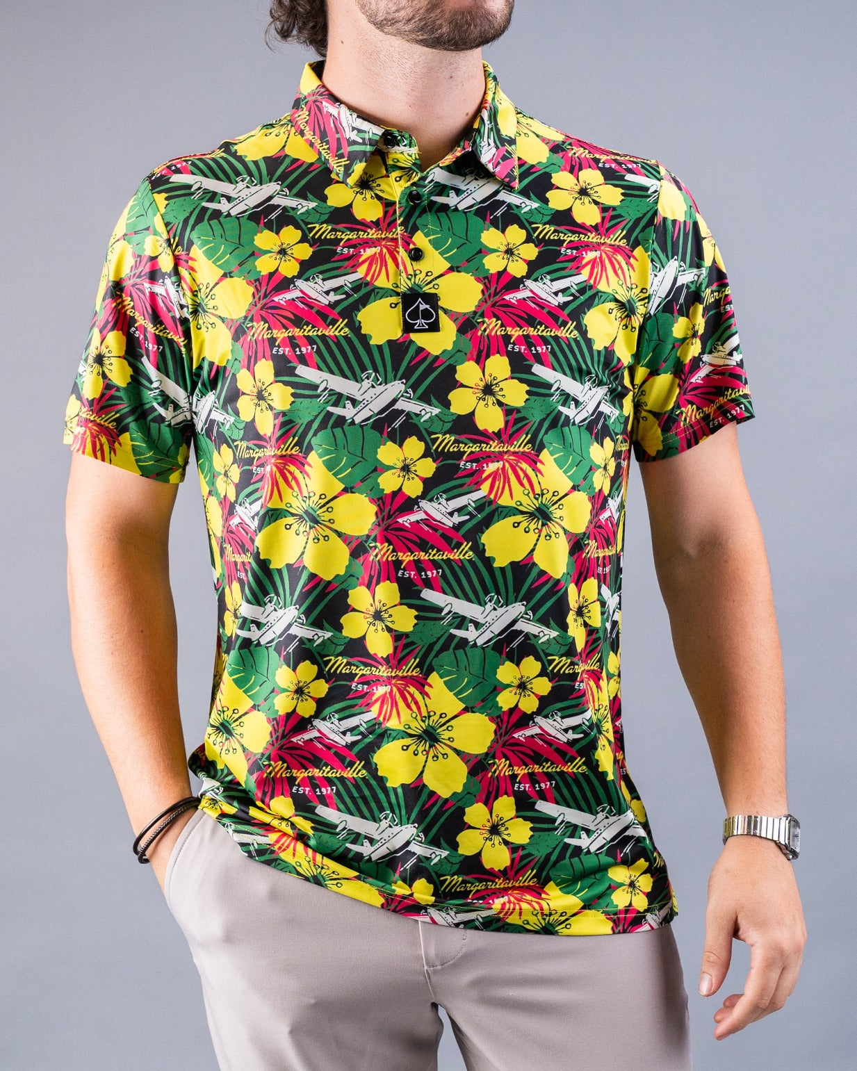 Vibrant Margaritaville Daydreamin' golf shirt featuring a tropical floral pattern in yellow and green tones.