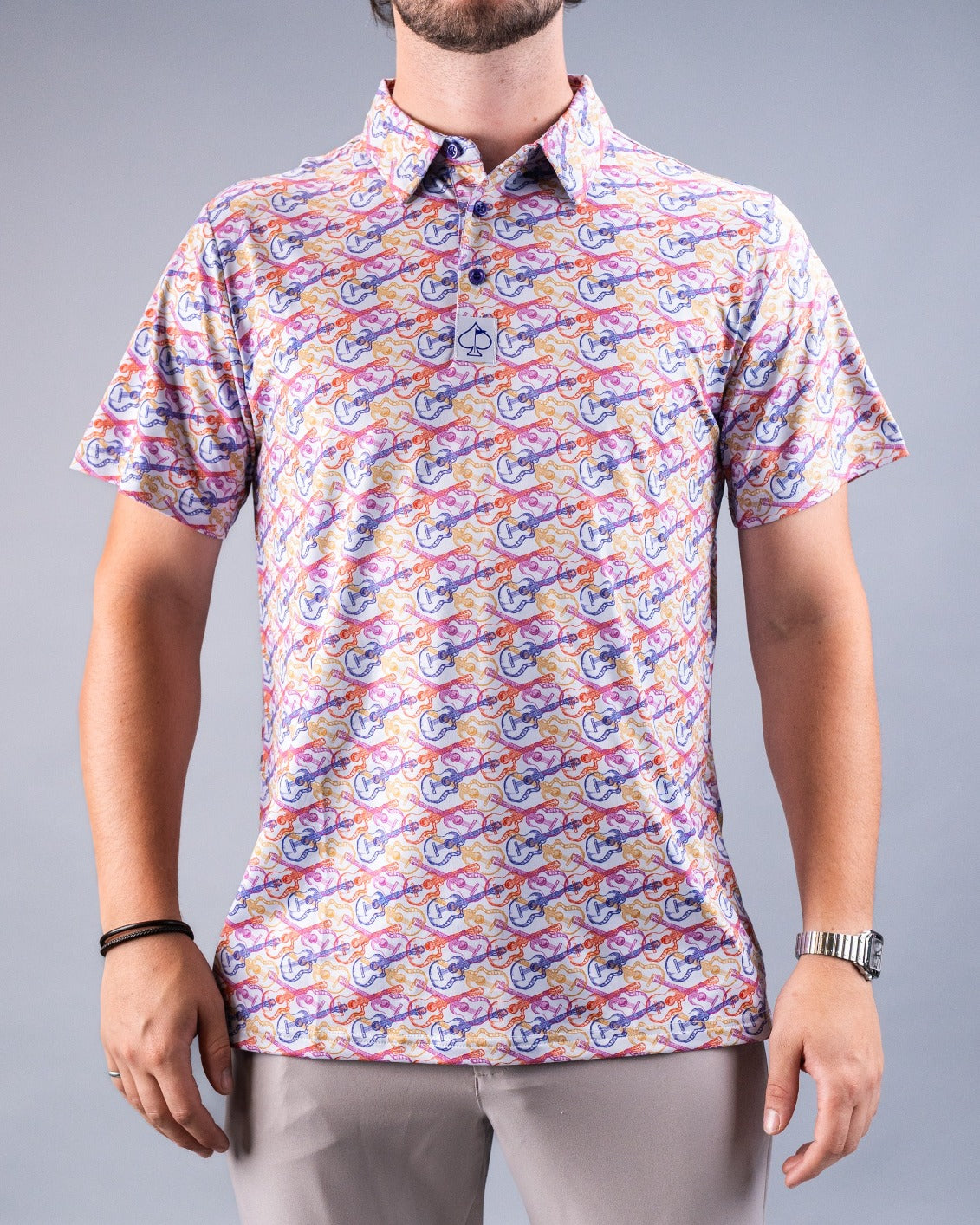 Men's Margaritaville polo shirt featuring a colorful, whimsical pattern of guitars and tropical motifs, perfect for casual wear.
