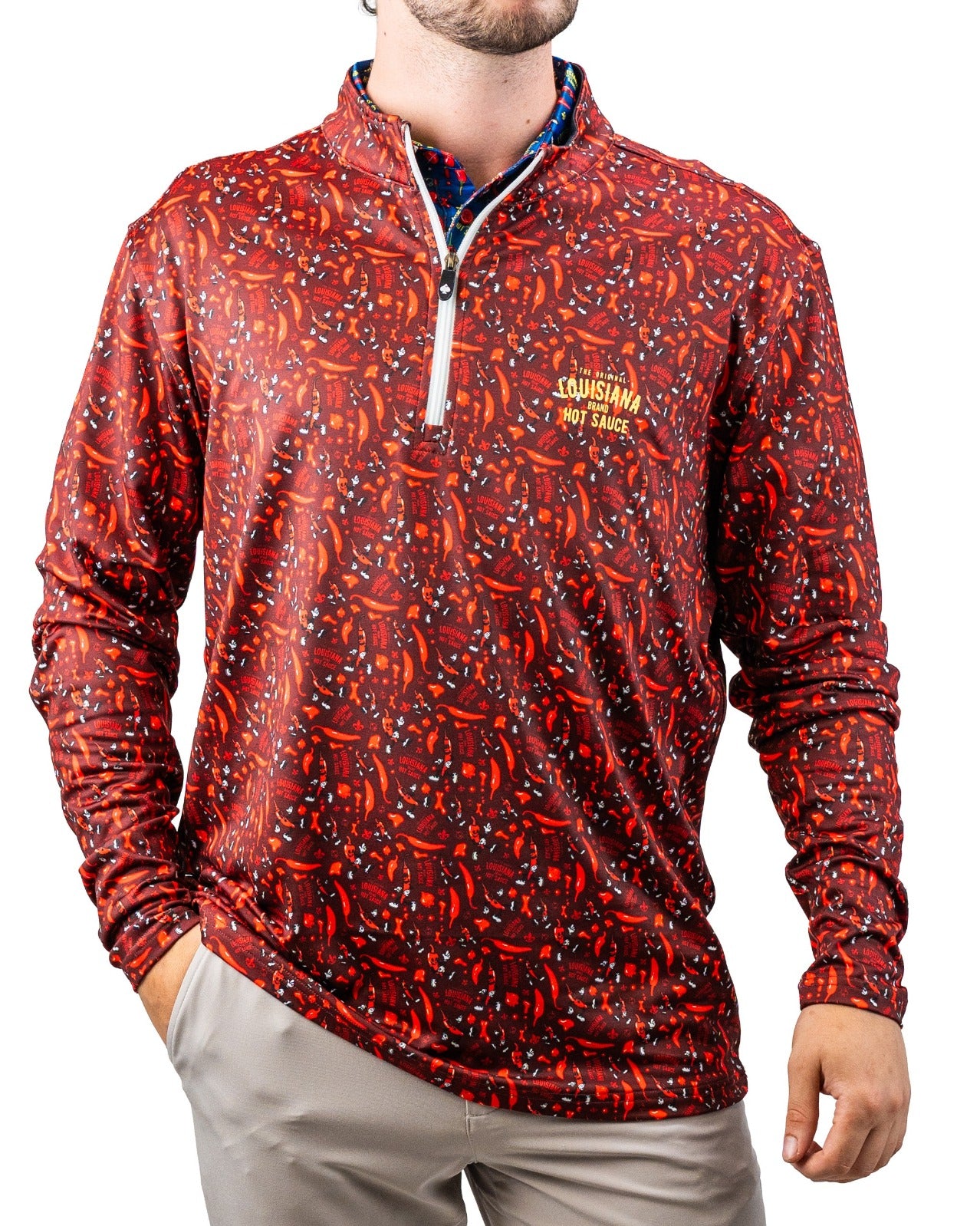 Red golf pullover with chili pepper and hot sauce print, quarter-zip collar, and "Louisiana Hot Sauce" logo embroidery.